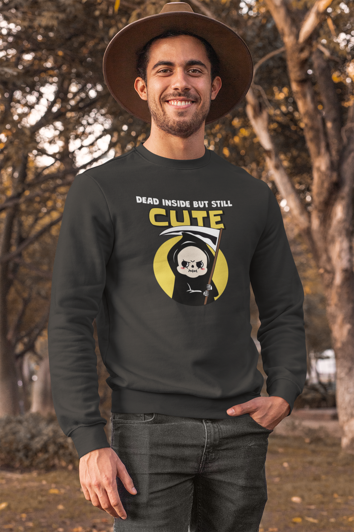 'Dead Inside but Still Cute' sweatshirt in black, man wearing it outdoors among trees, funny grim reaper pun gift