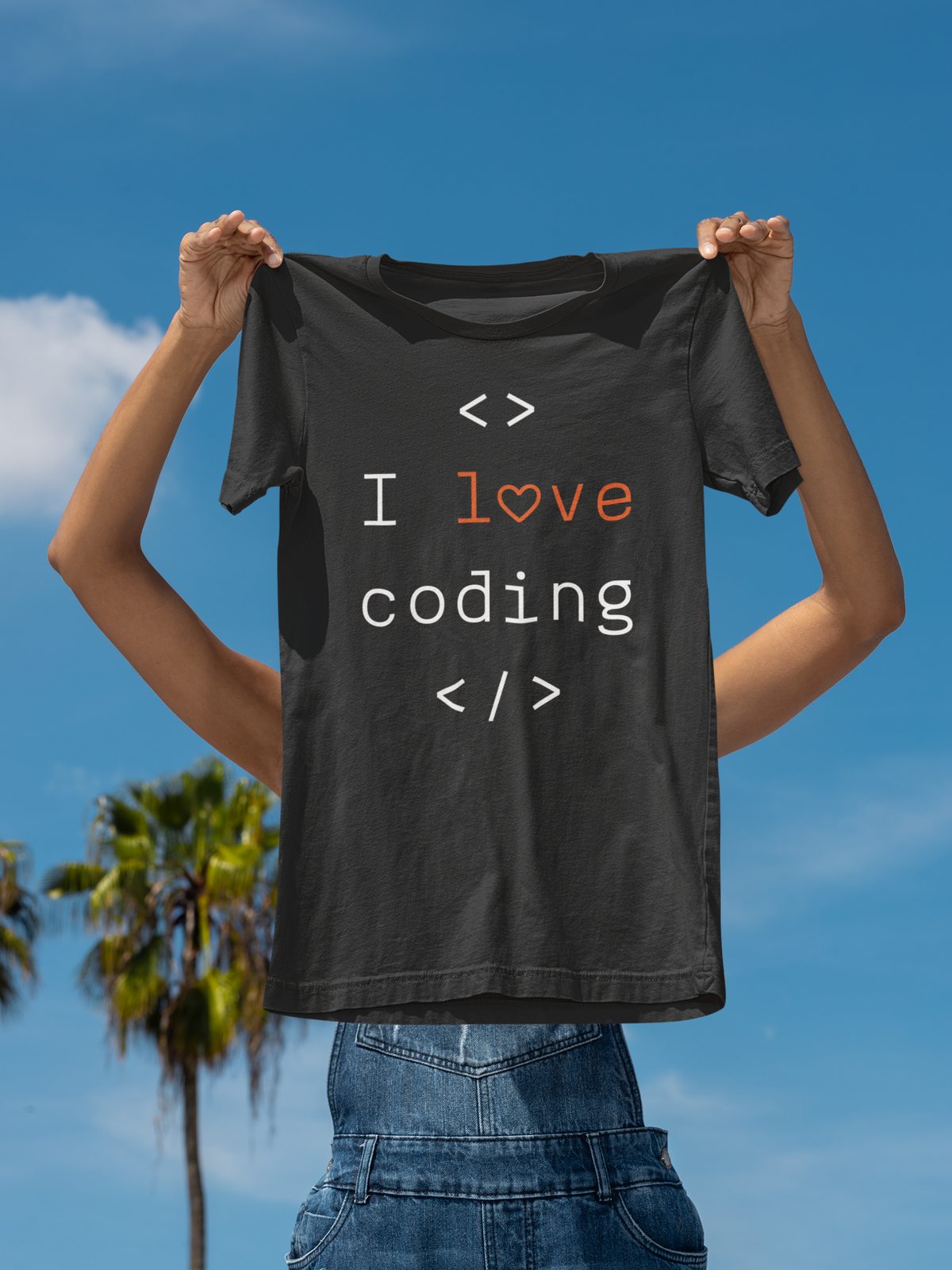 'I Love Coding' t-shirt in black, held up against a blue sky