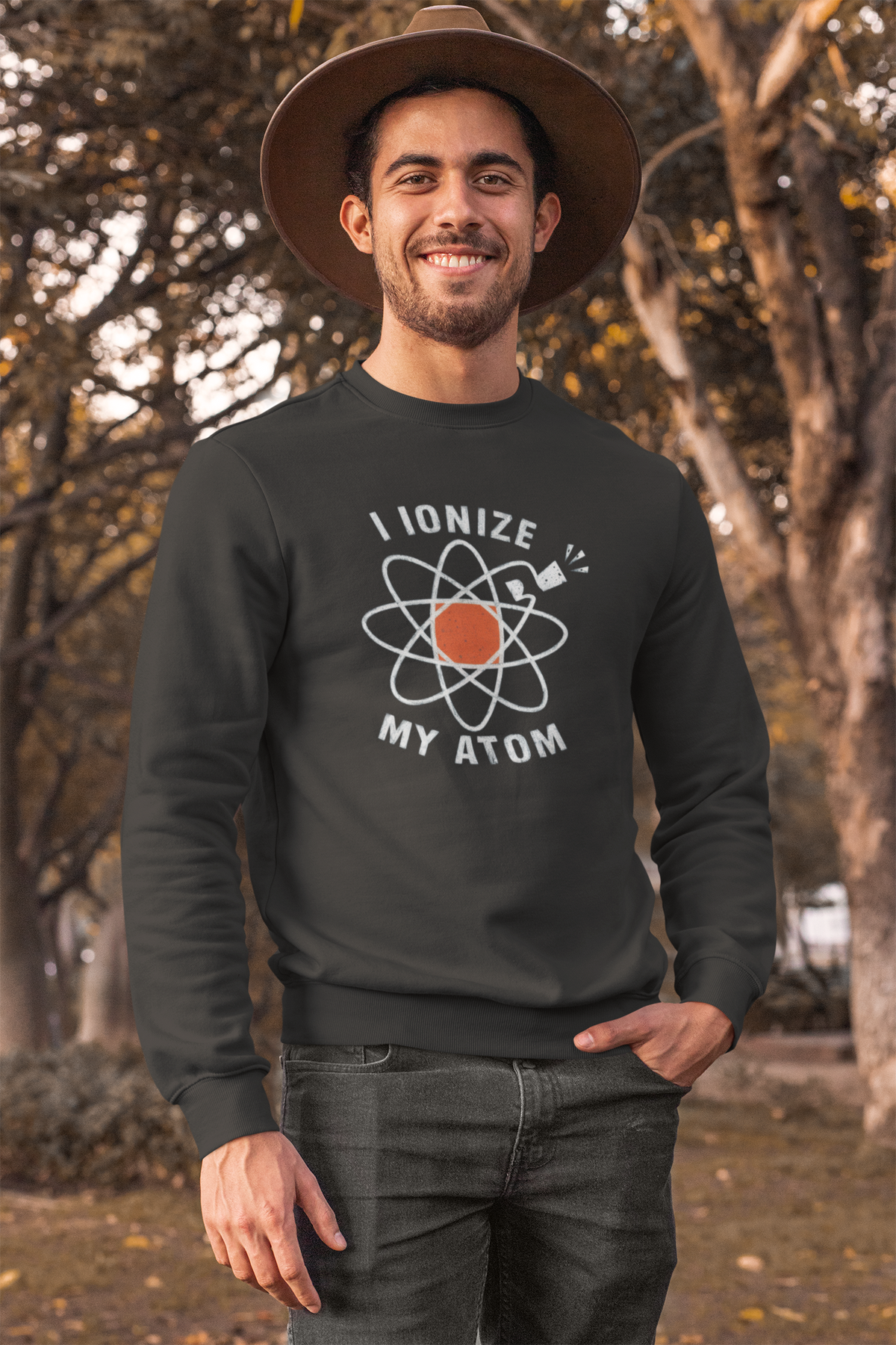 'I Ionize My Atom' sweatshirt in charcoal, man wearing it outdoors, funny gift for chemistry teachers