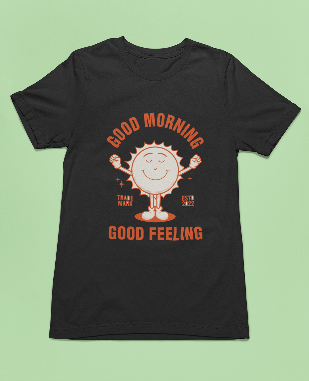 'Good Morning Good Feeling' sun t-shirt in black, flat lay on green background, uplifting gift shirt