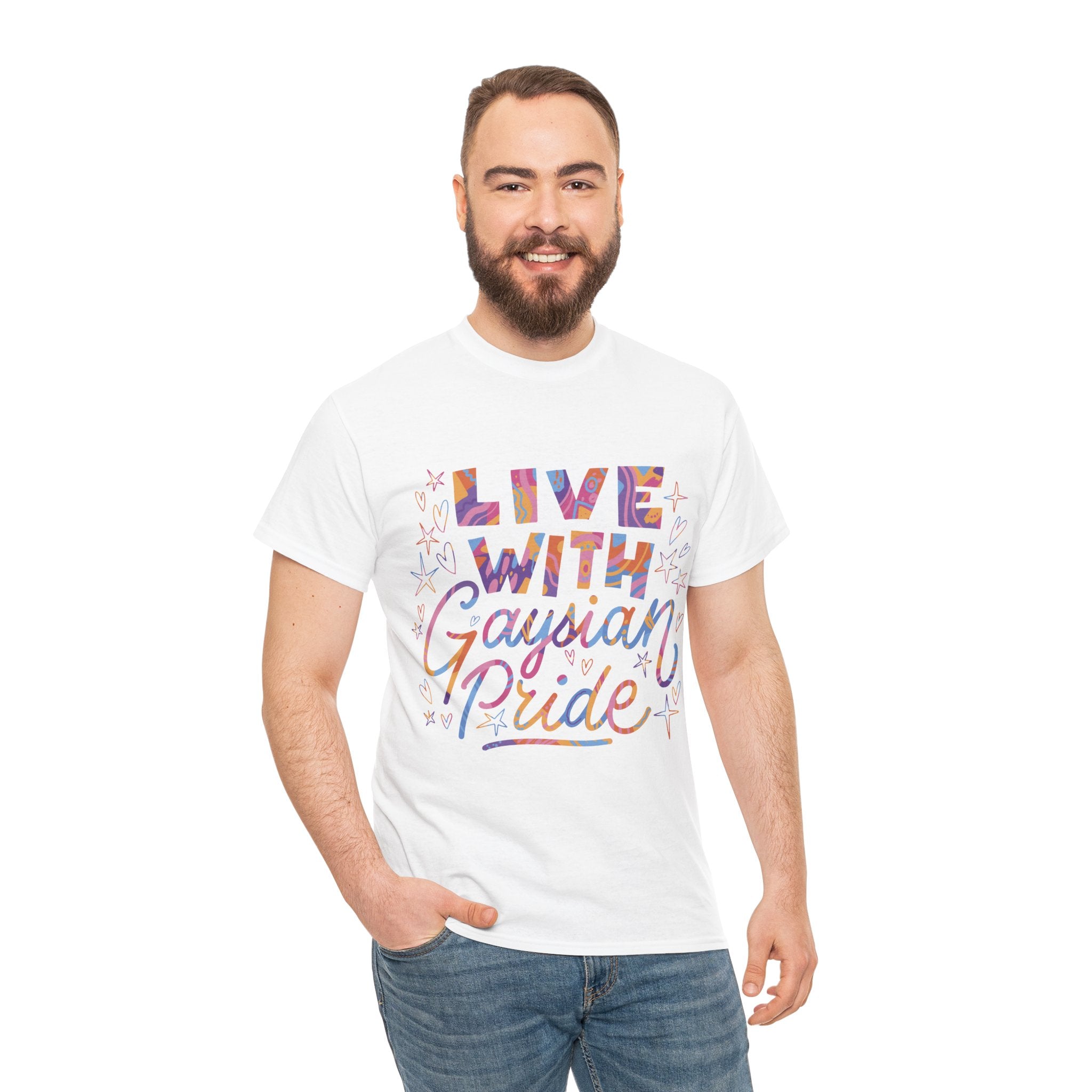 A bearded person wearing a white "Live With Gaydian Pride" T-shirt stands confidently and smiles, exuding true nerd culture vibes with one hand casually in their pocket.