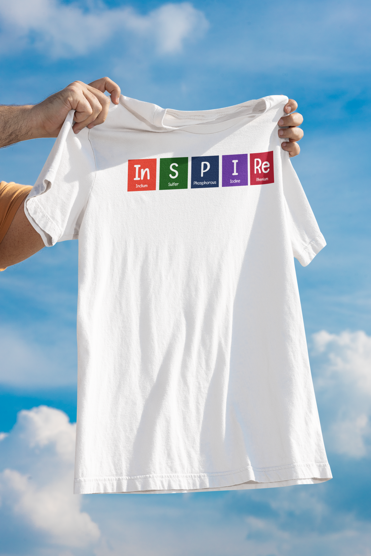 'InSPIRe' periodic table t-shirt in white, held up against a cloudy sky, funny chemistry pun gift