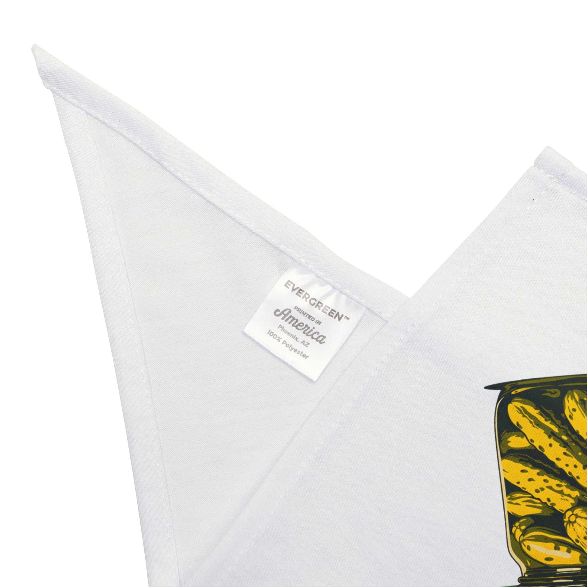 Close-up of a white fabric with a sewn "EVERGREEN America 100% polyester" label, plus part of the yellow and black Dill Seeker - Pet Bandana design on the right—ideal for pet owners who love geek culture flair.