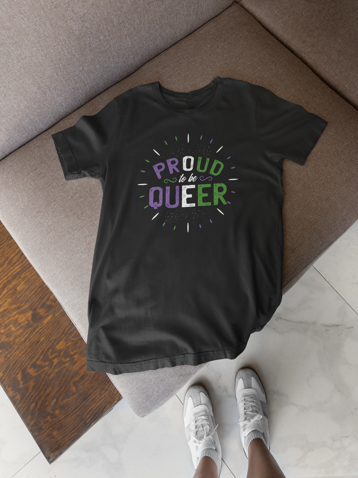 'Proud to Be Queer' T-shirt in black, flat lay on a wood floor, funny gift for queer pride