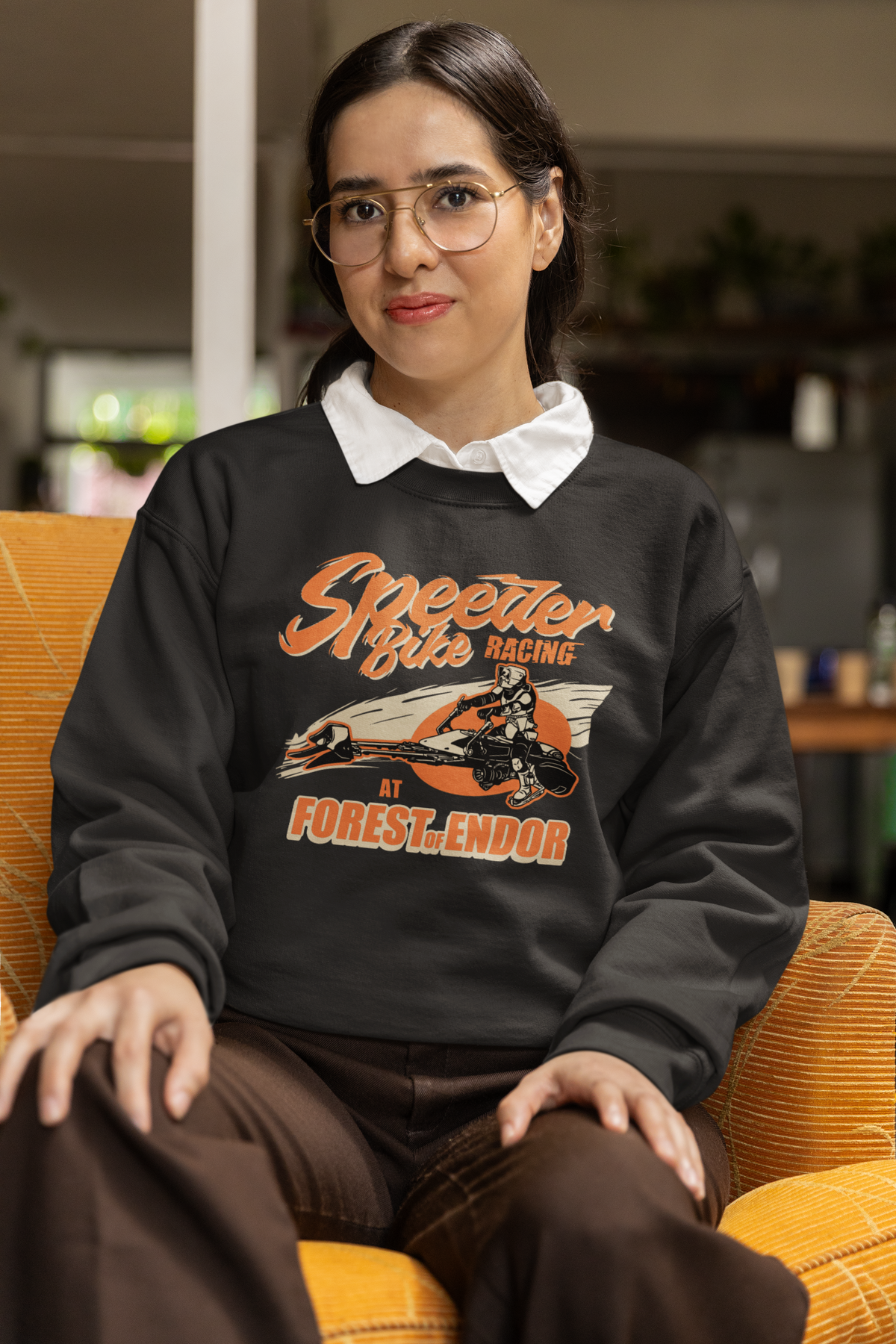 Speeder Bike Racing graphic sweatshirt in black, woman wearing it seated indoors, funny sci-fi gift for her