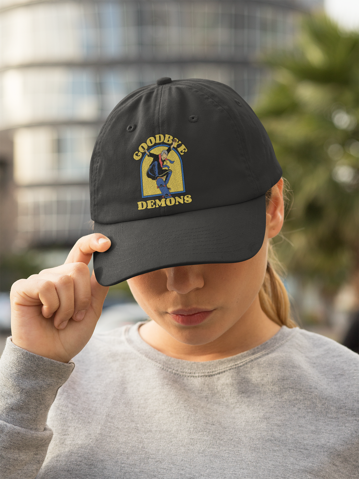 'Goodbye Demons' funny exorcist skater dad hat in black, woman wearing it in city street, funny gift