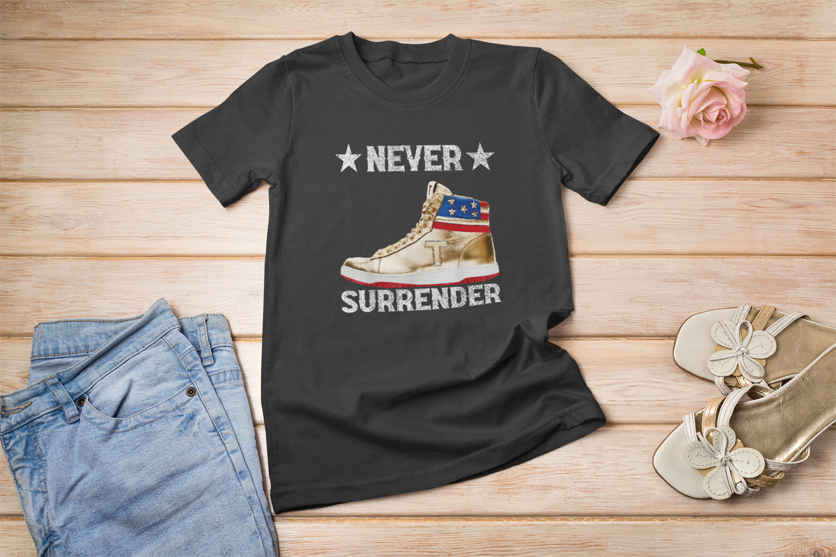 'Never Surrender' sneaker t-shirt in black, flat lay with sneakers, funny sneakerhead gift