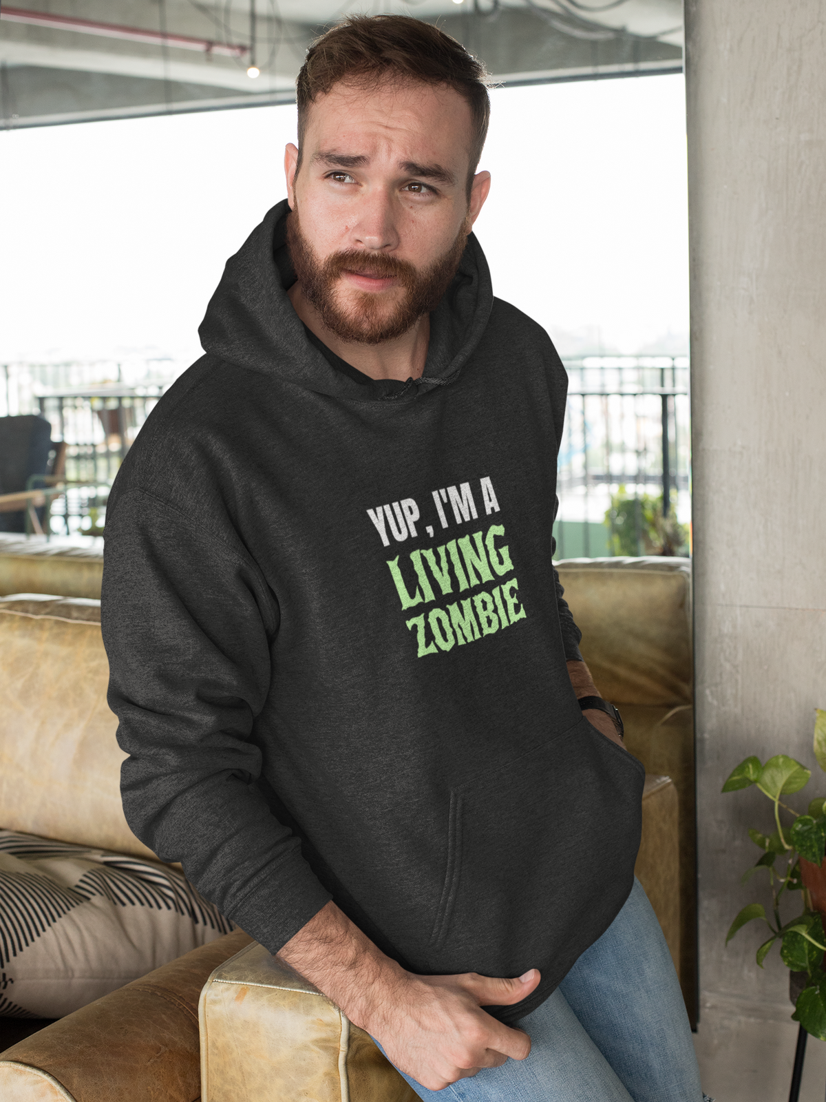'Yup, I'm a Living Zombie' hoodie in charcoal, bearded man wearing it indoors, funny zombie gift idea