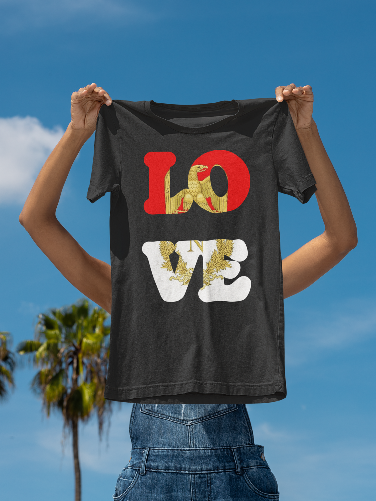 'LOVE Listenbourg' t-shirt in black held up outdoors under a blue sky