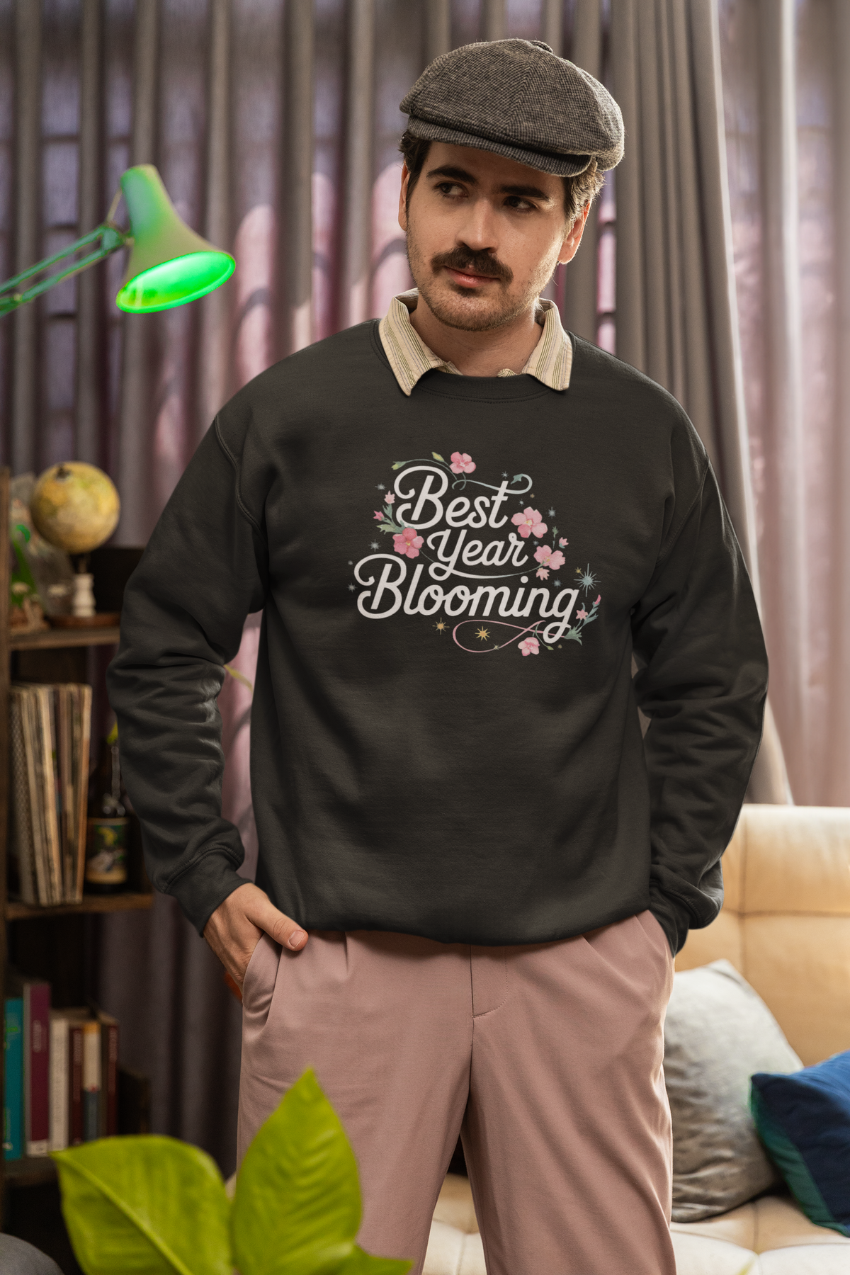 'Best Year Blooming' sweatshirt in olive green, man wearing it indoors with newsboy cap, cozy plant lover gift