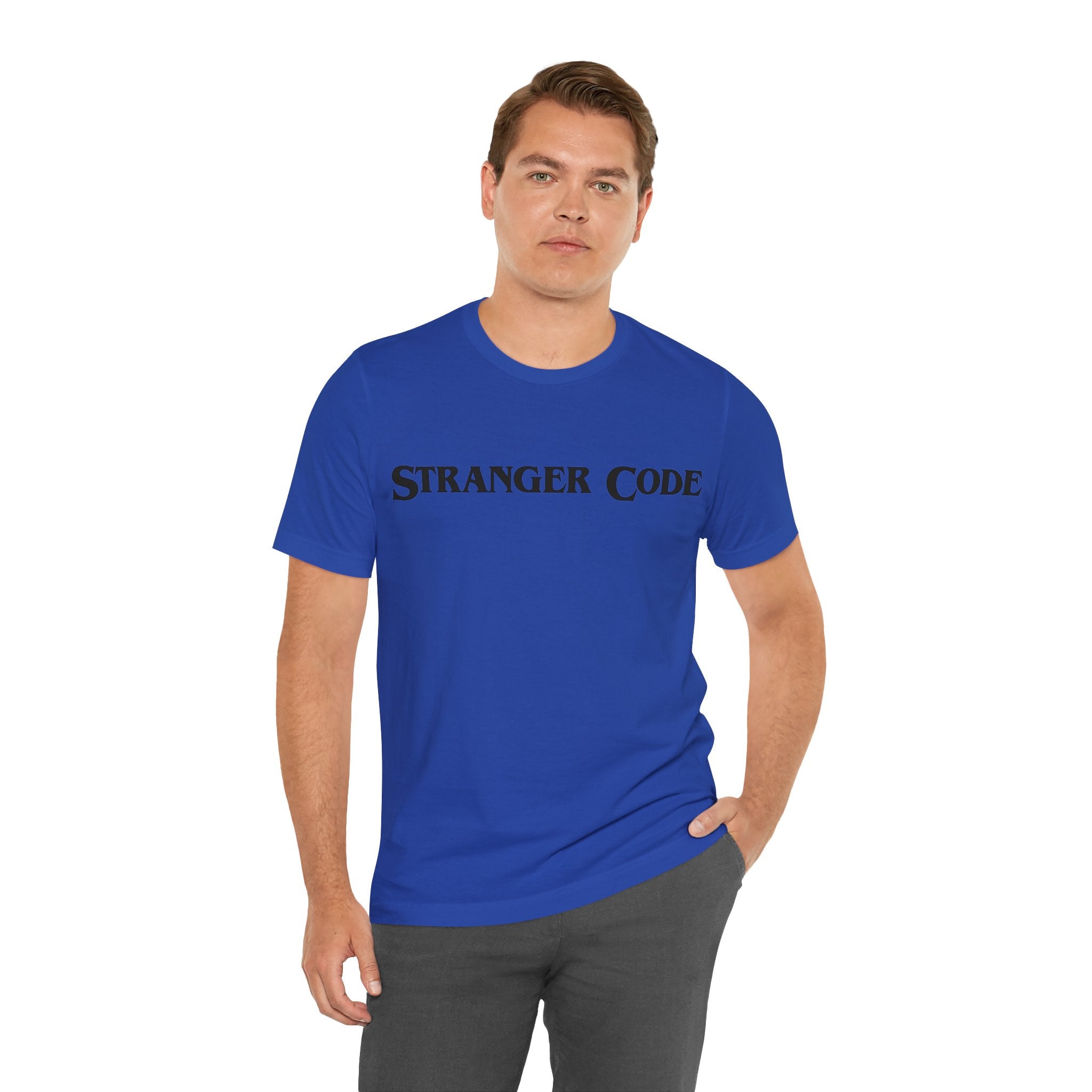 A person is wearing the Stranger Code Tee Shirt, a classic unisex jersey tee featuring "Stranger Code" printed on it. Made from soft cotton for comfort, its quality print provides a stylish touch.