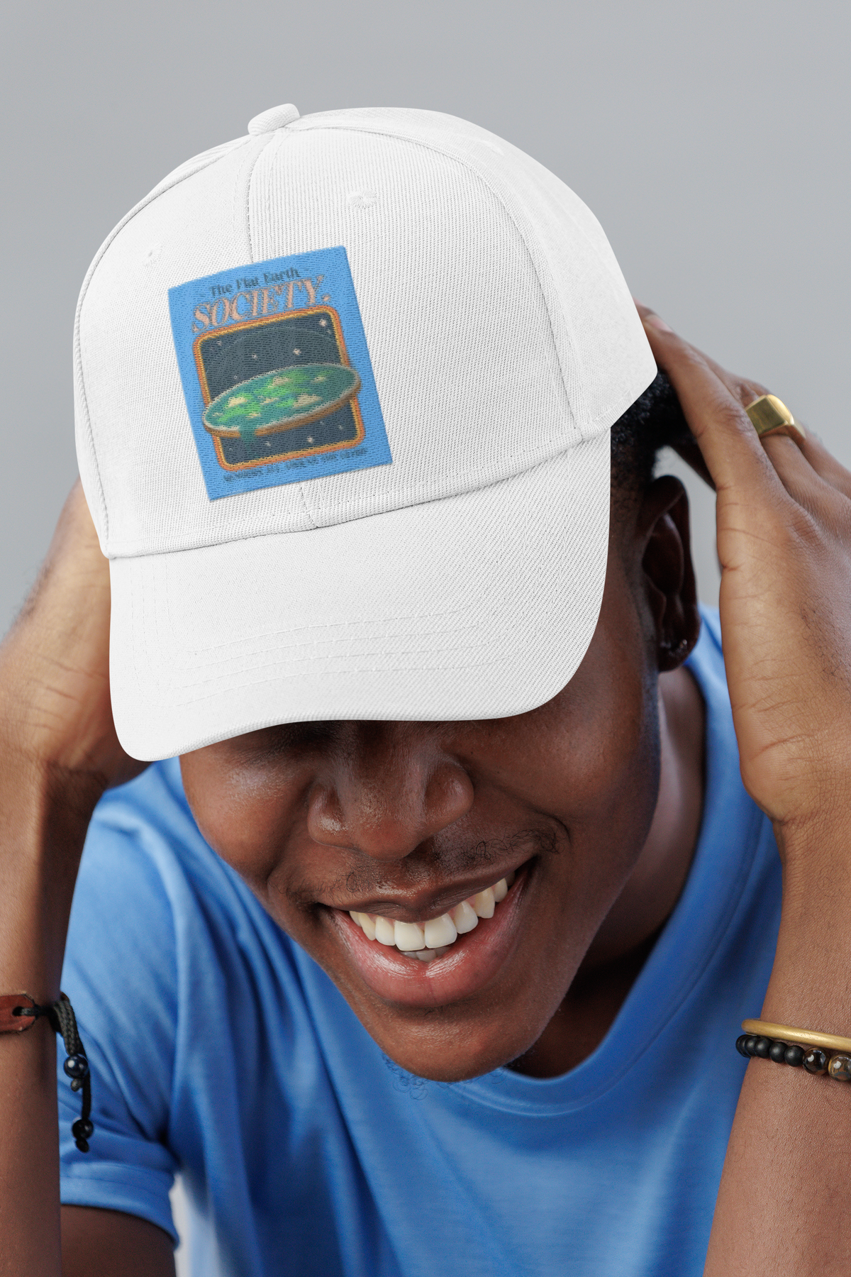 Flat Earth Society science satire dad hat, smiling man in a studio, lifestyle mockup, Geekpsters