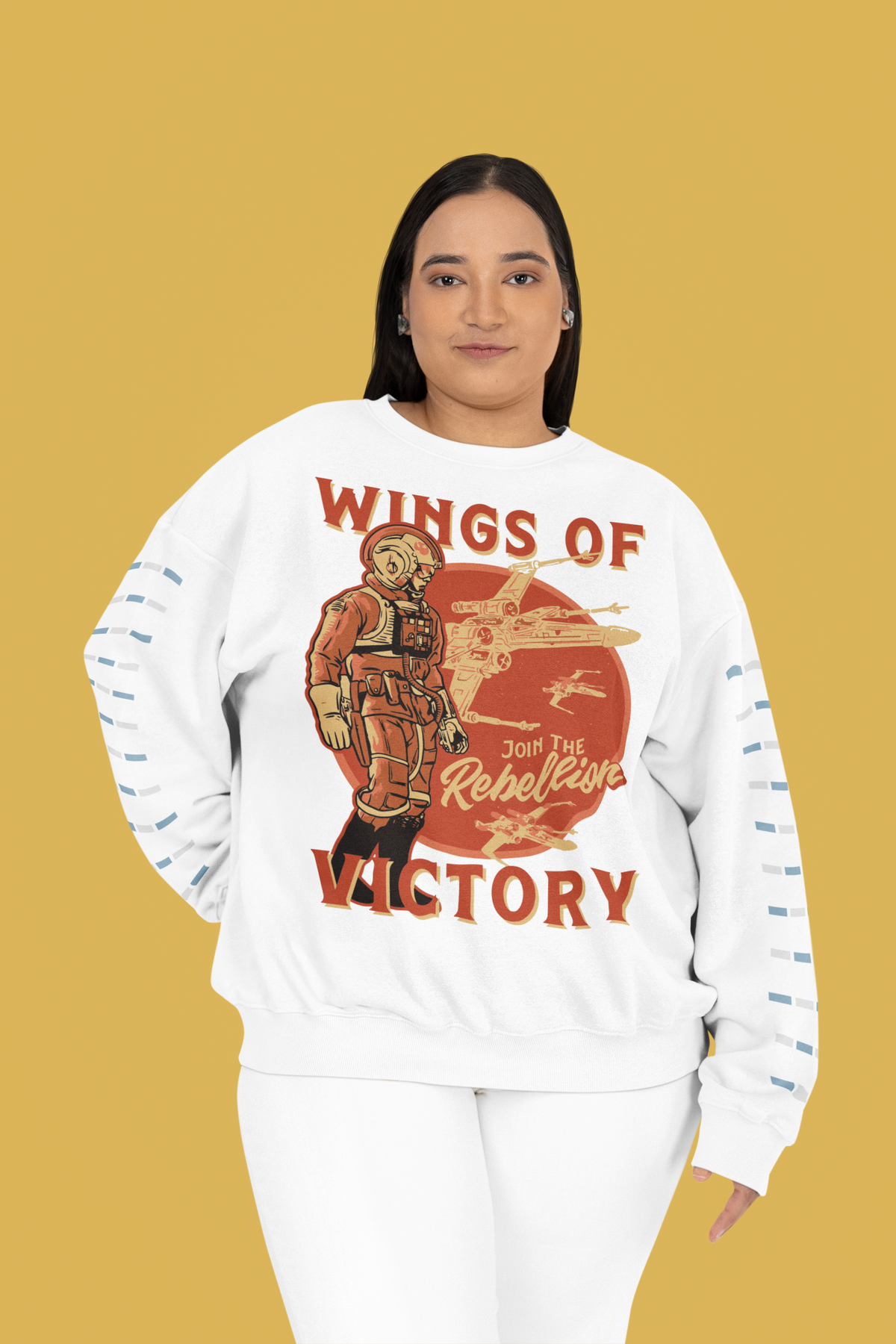 'Wings of Victory' sweatshirt in white, woman wearing it on mustard background, rebel warrior sweatshirt