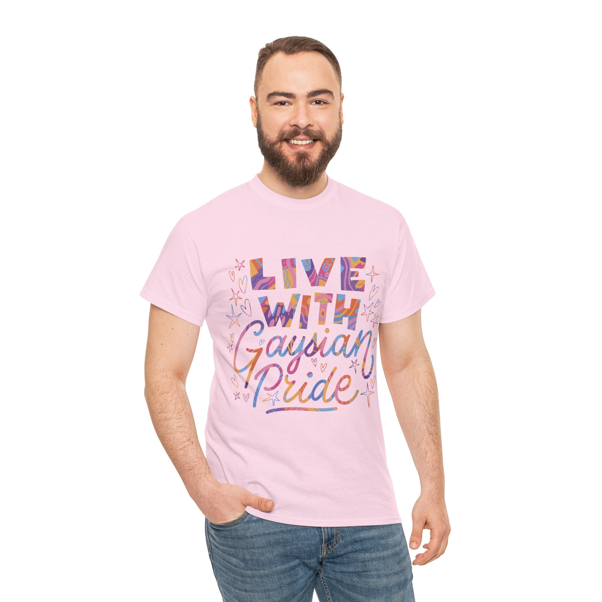 A person wearing a pink "Live With Gaydian Pride" T-shirt, featuring vibrant letters and a hint of nerd culture, smiles against a plain white background.