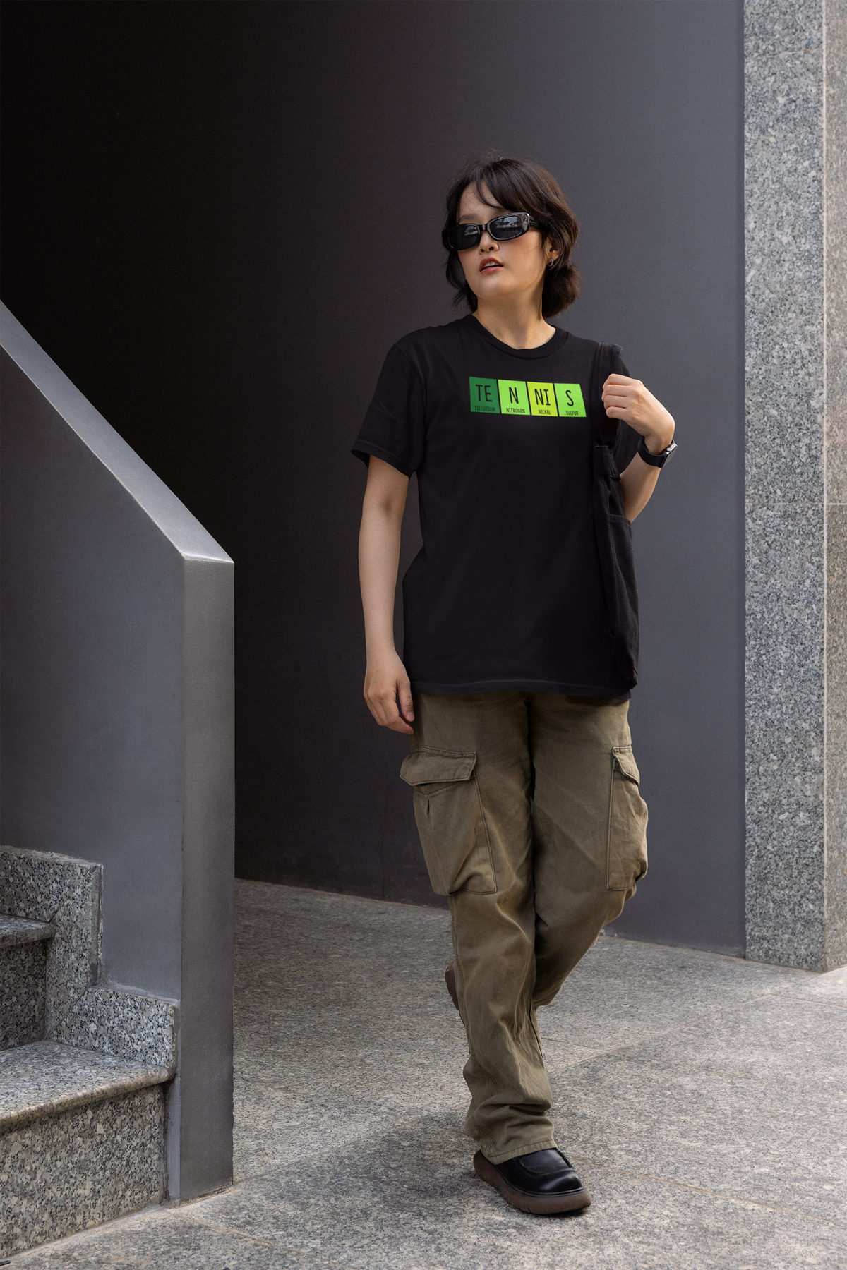 'Tennis' periodic table women's t-shirt in black, woman wearing it on stairs outdoors, funny science tennis gift