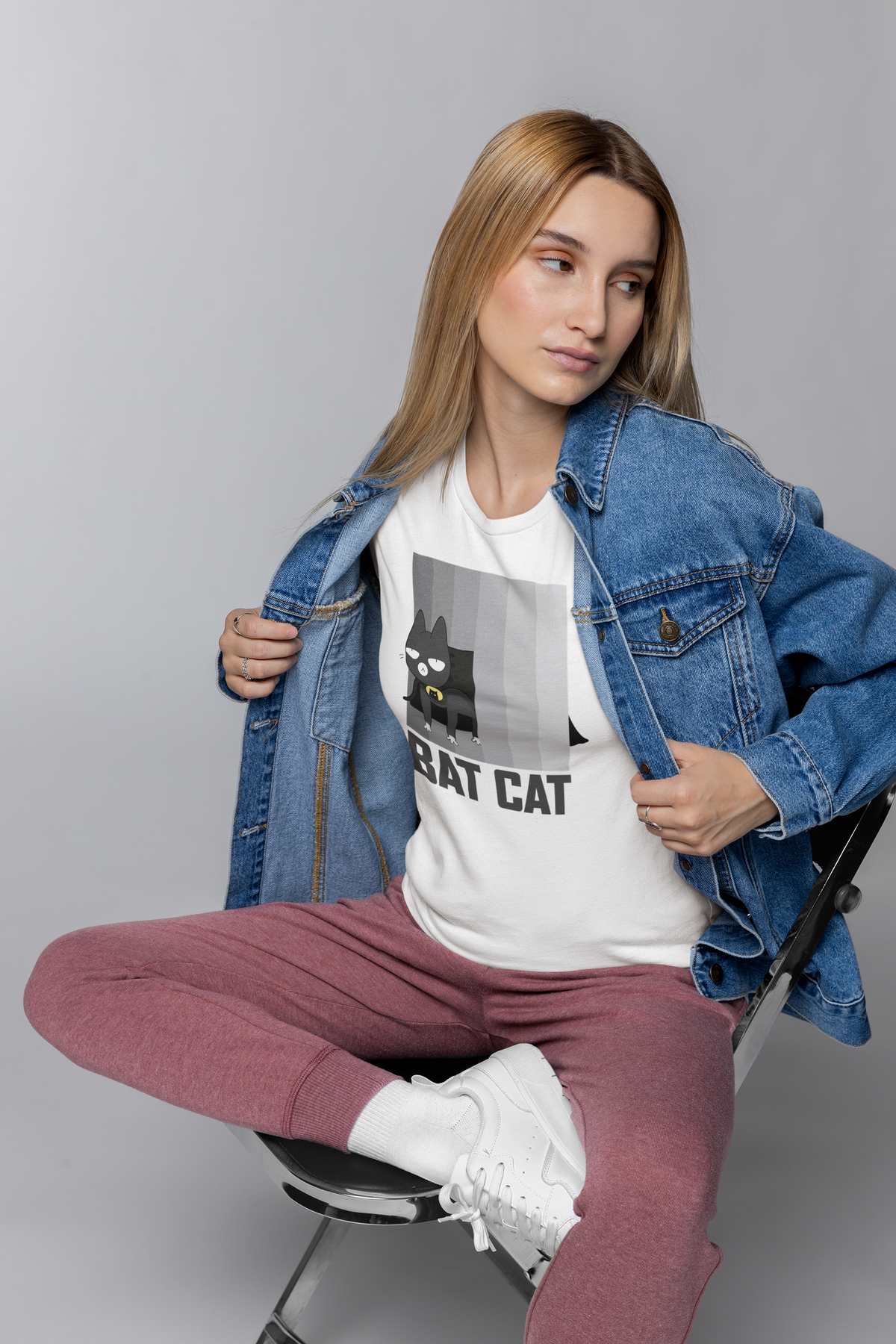 'Bat Cat' parody T-shirt in white, woman wearing denim jacket over it, superhero cat gift tee