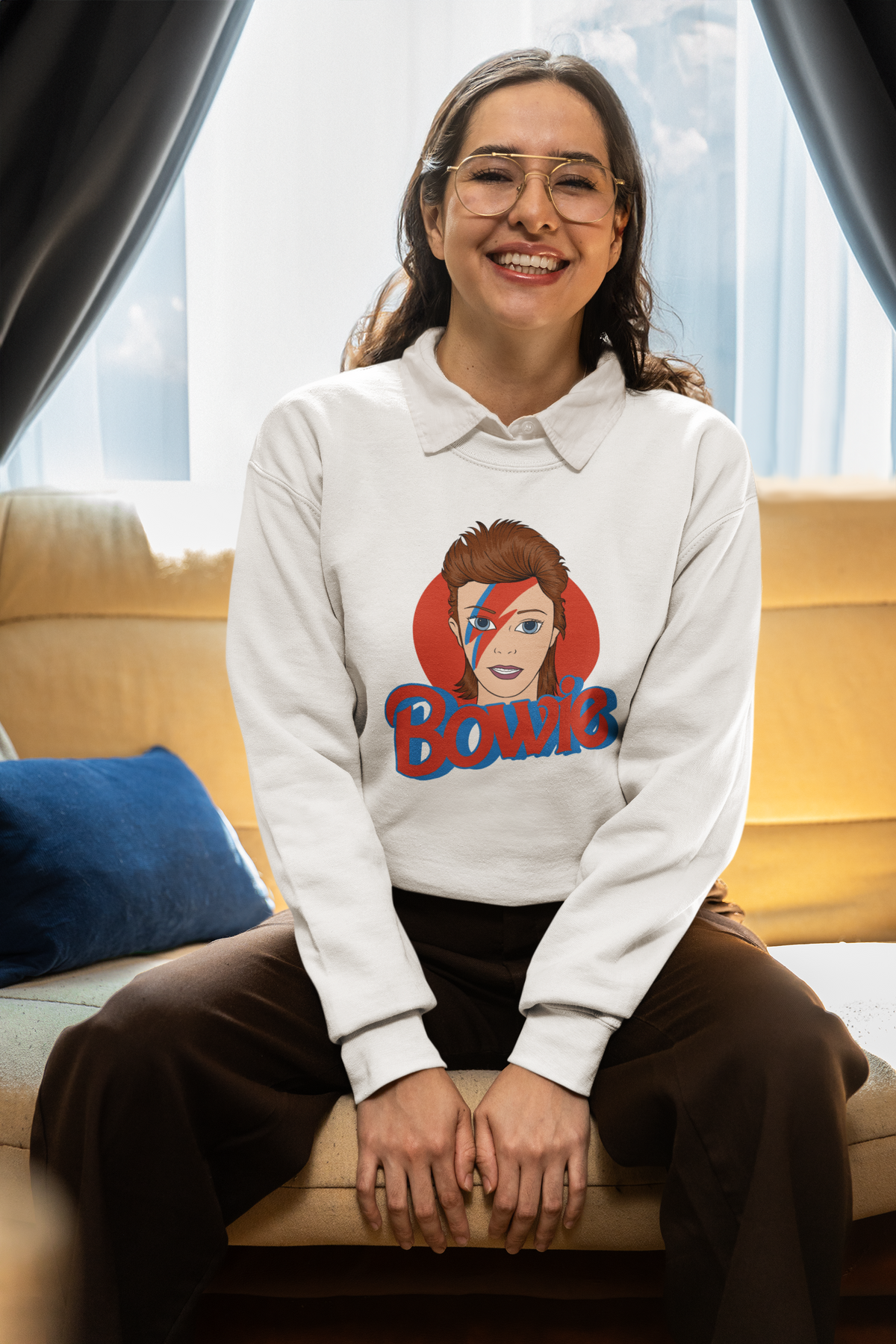 Bowie lightning bolt sweatshirt in white, woman wearing it seated on a couch, music fan gift for her