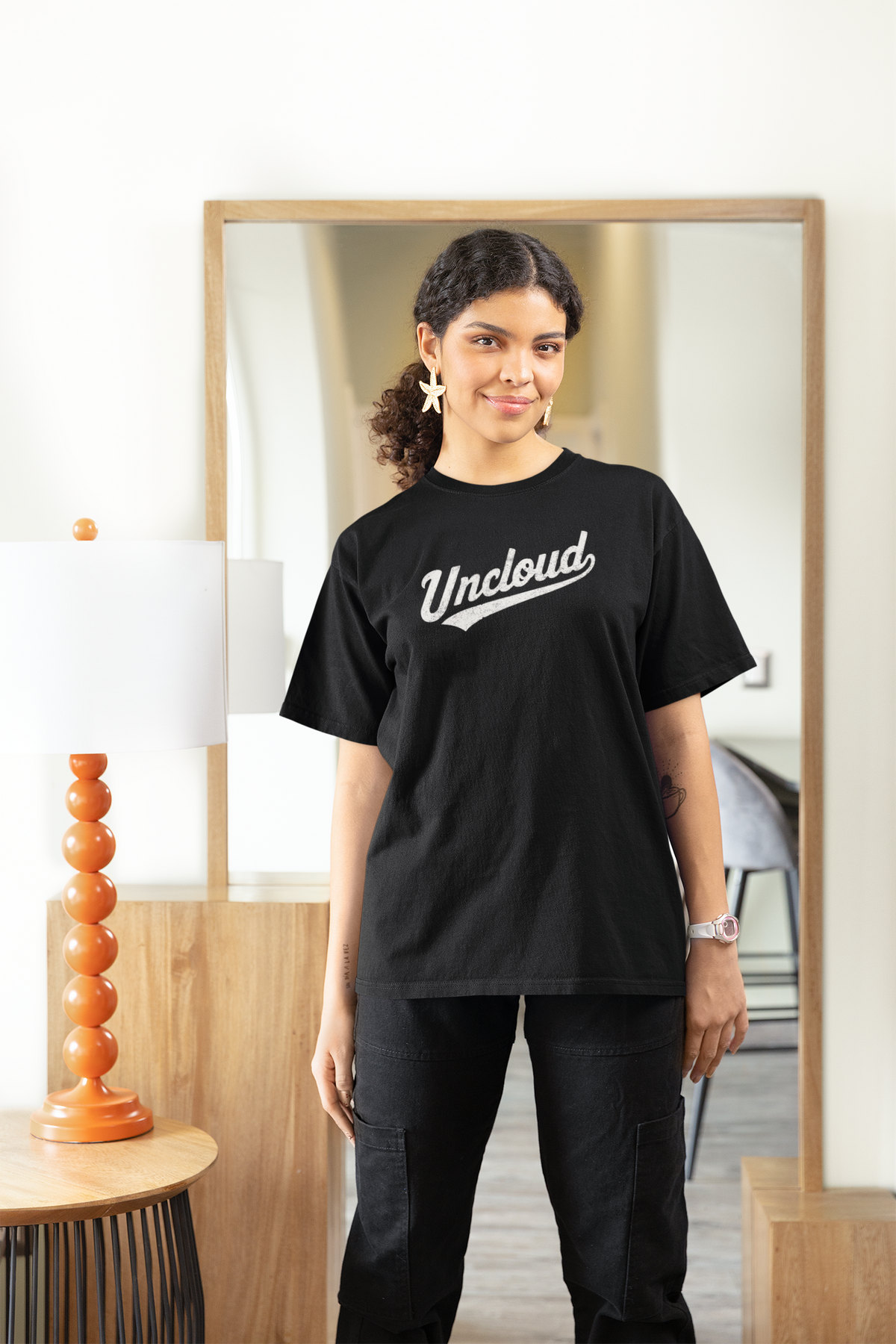 Uncloud script logo t-shirt in black, woman wearing it indoors near a mirror, funny coder pun gift