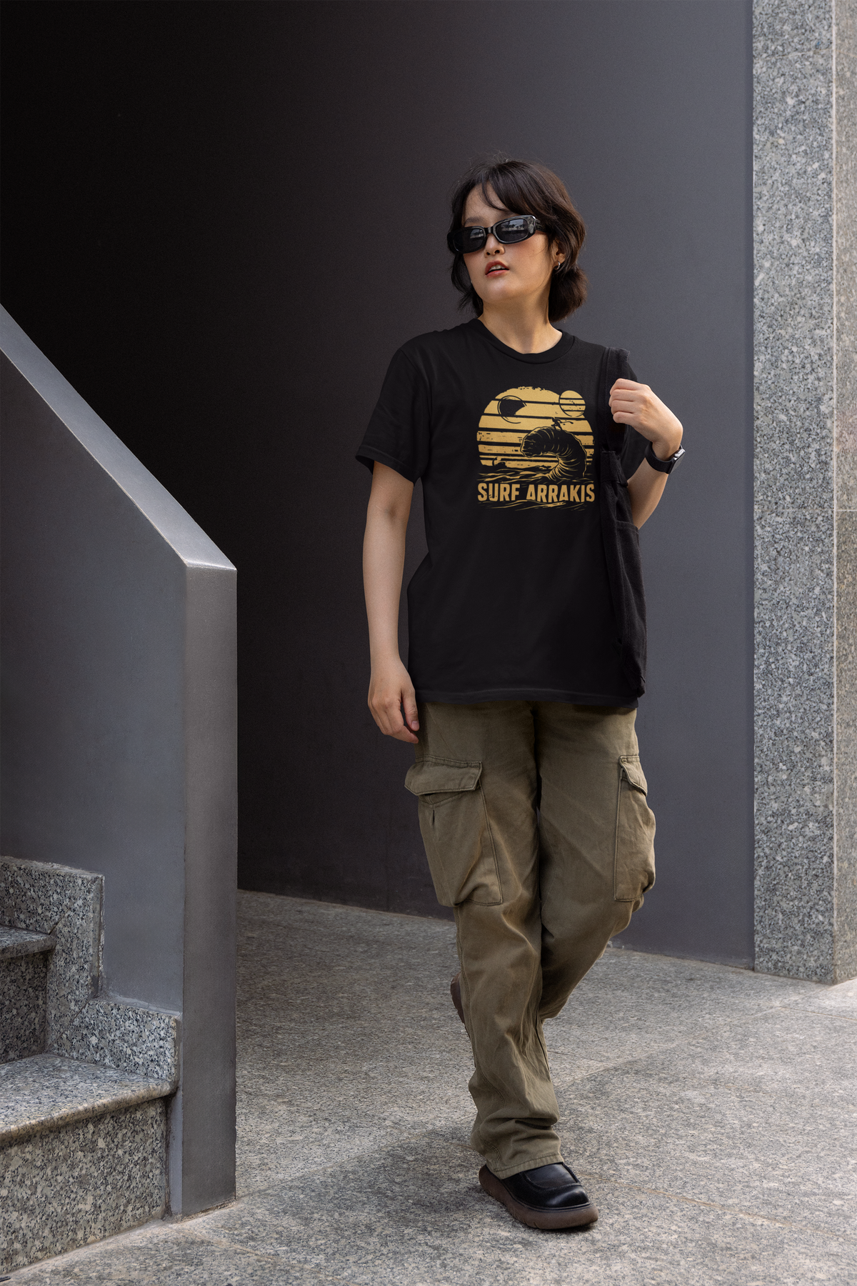 Surf Arrakis sandworm t-shirt in black, man wearing it outdoors on city stairs, funny sci-fi gift