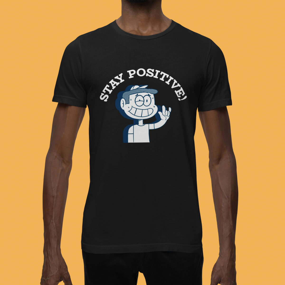 'Stay Positive' cartoon graphic t-shirt in black, man wearing it, mustard backdrop, funny gift