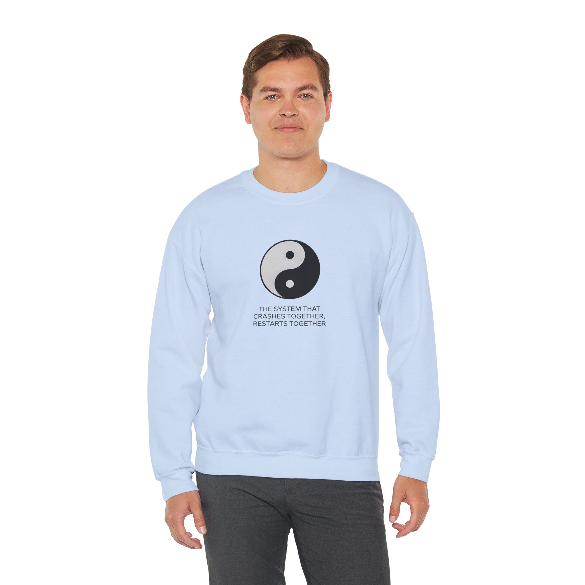 Man wearing a light blue "A System That Crushes Together Restarts Together" sweatshirt featuring a yin-yang symbol, perfect for nerds.