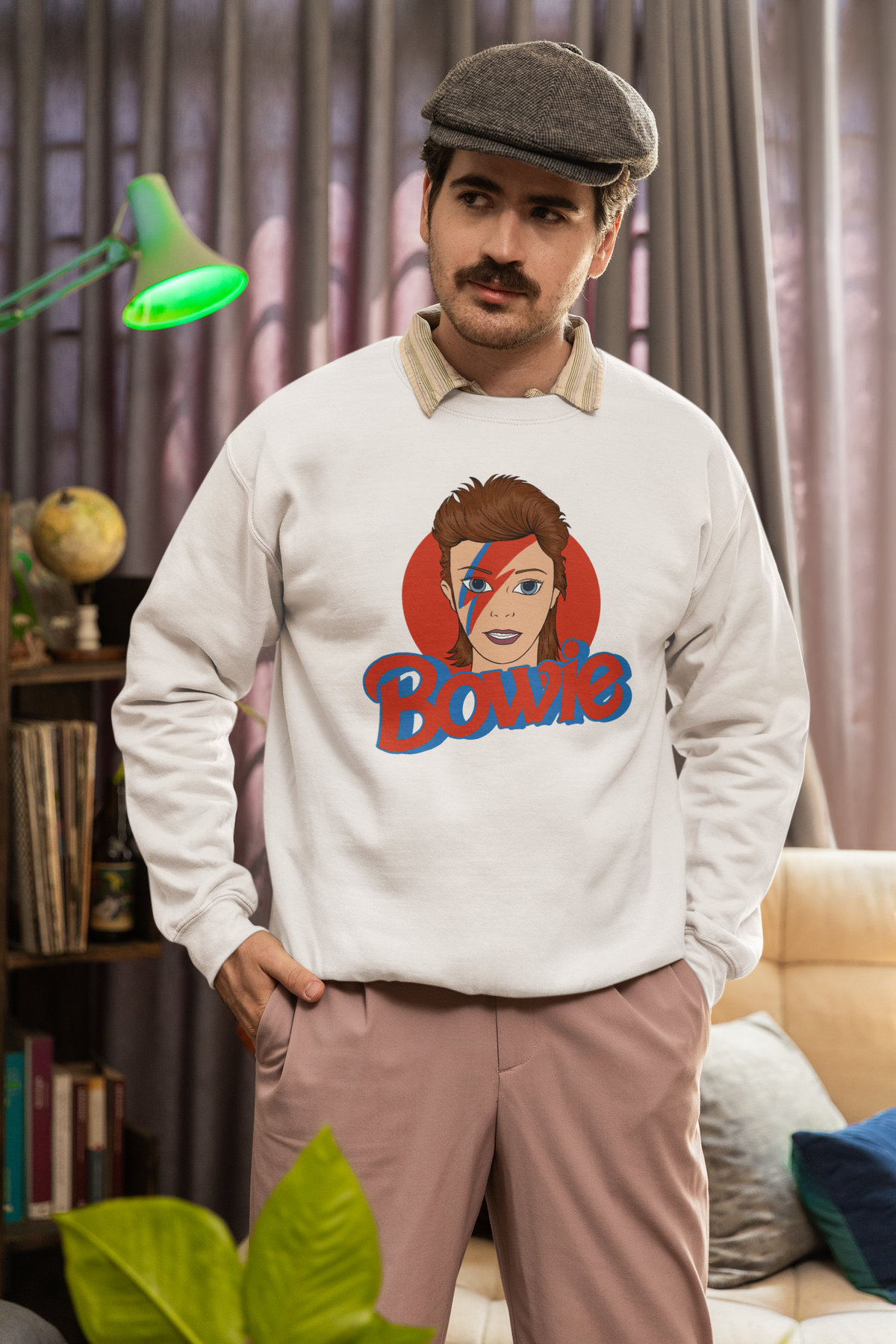 Bowie lightning bolt sweatshirt in sand, man in a flat cap wearing it indoors, rock star gift