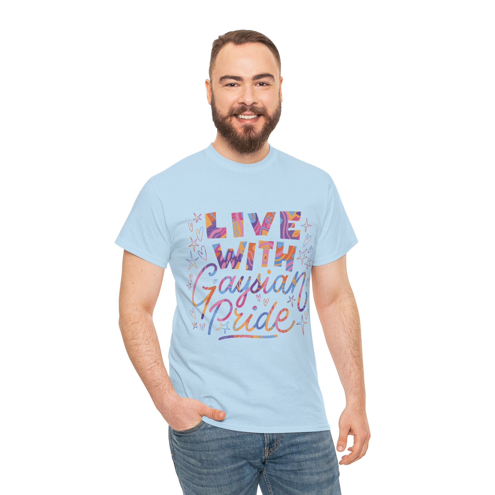 A bearded individual stands proudly against a white background in a light blue "Live With Gaydian Pride" T-shirt, celebrating nerd culture with colorful lettering.