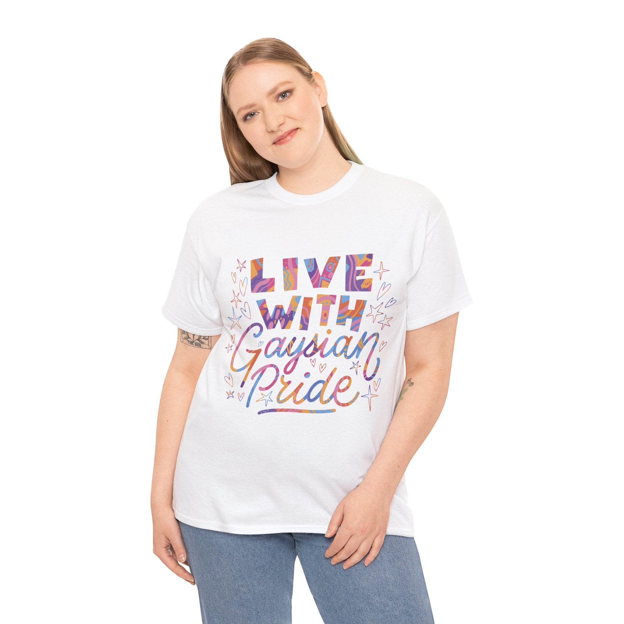 Against a plain white background, someone stands wearing the "Live With Gaydian Pride" t-shirt featuring bright text and small decorative hearts and stars, celebrating nerd culture with style.