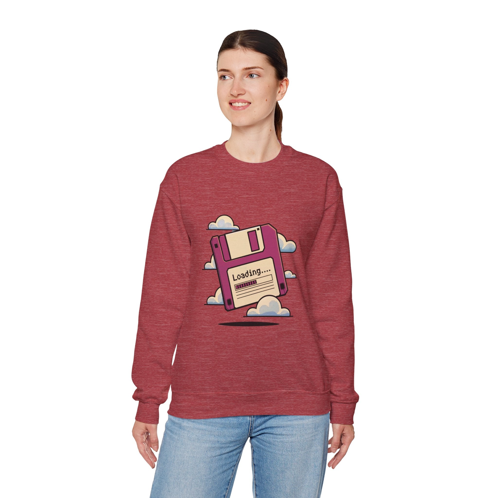 A woman wears the "Floppy disk - Sweatshirt," a geek chic heavyweight cotton top with a front graphic of a floppy disk, clouds, and the word "Loading...