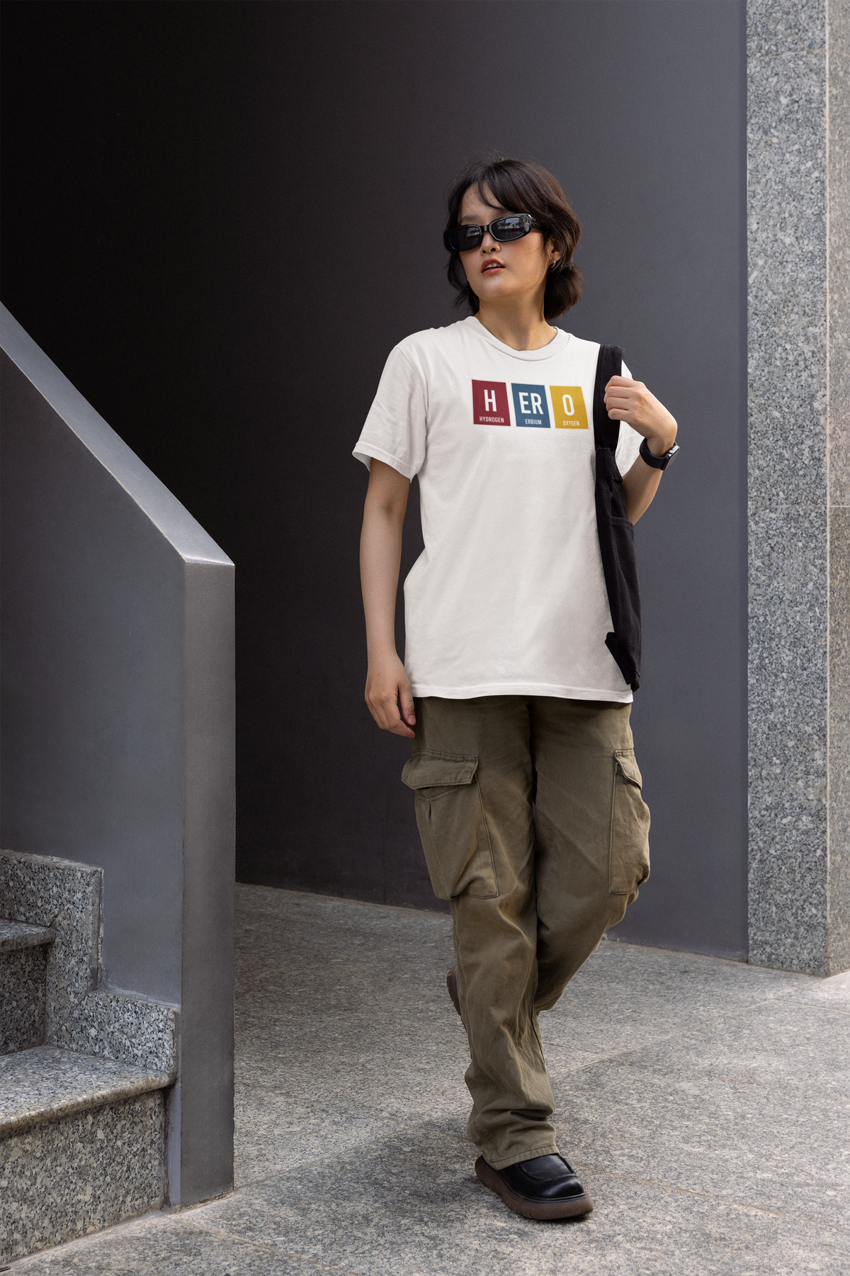 'HERO' periodic table t-shirt in white, woman wearing it on outdoor stairs, funny science tee