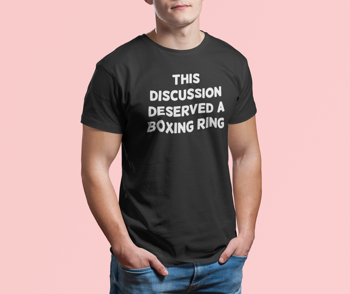 'This Discussion Deserved a Boxing Ring' t-shirt in black, man modeling it on pink background, funny sarcastic gift