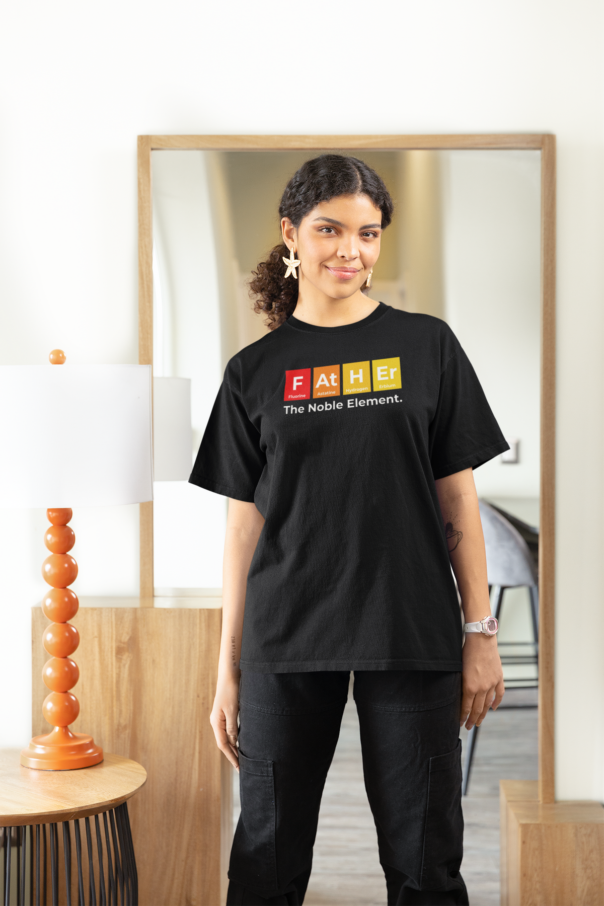 'Father: The Noble Element' women's tee in black, woman wearing it at home, funny periodic table gift