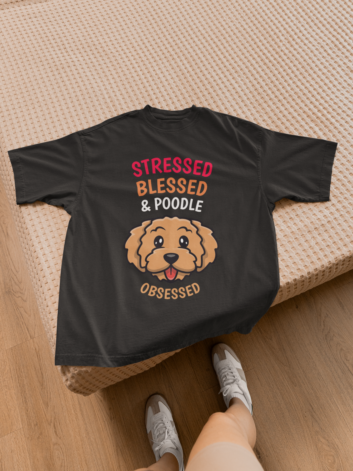 'Stressed Blessed & Poodle Obsessed' women's t-shirt in black, close-up flat lay on bed, dog gift