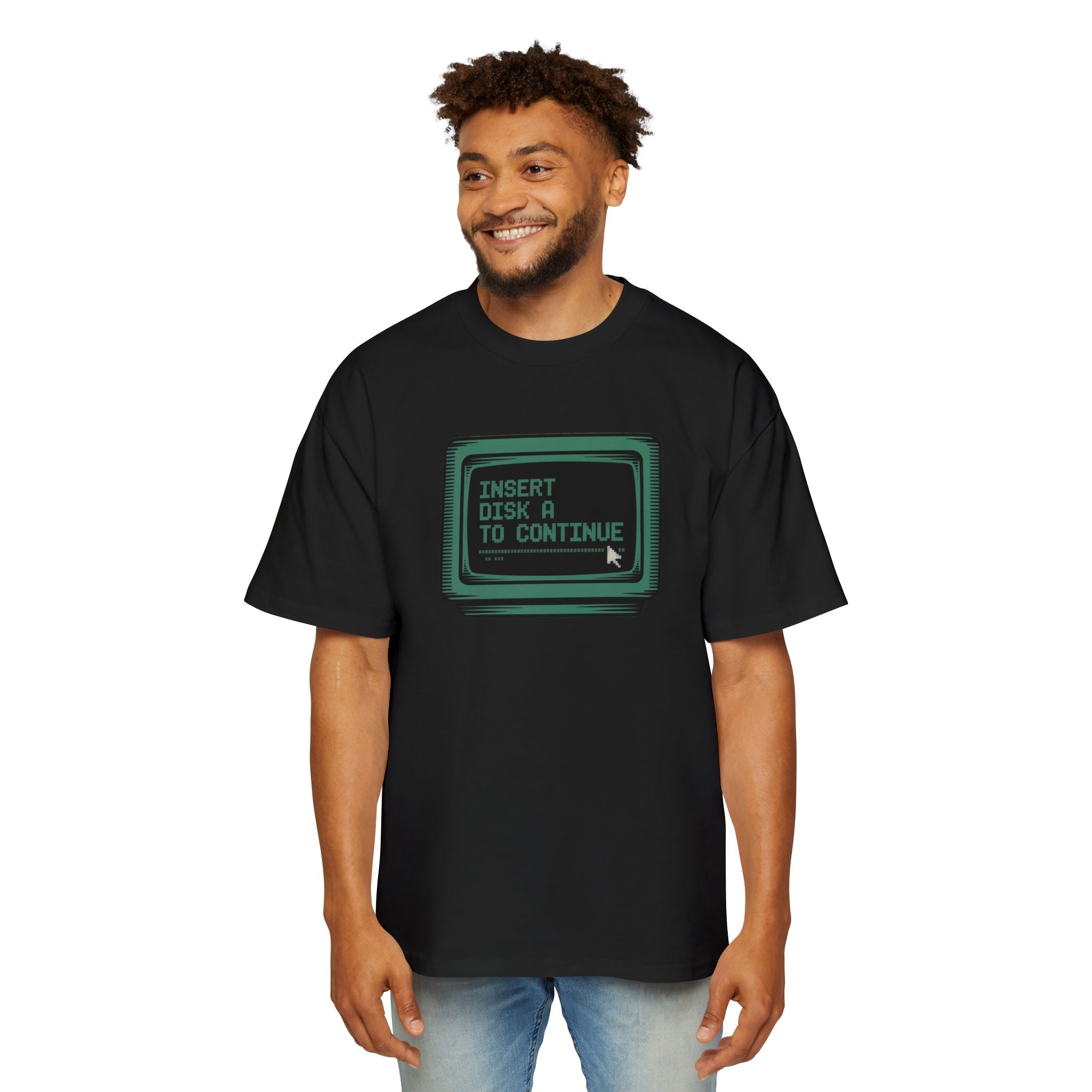 A man in the Insert Disk A to Continue - Heavy Oversized Tee, featuring a vintage computer screen with the phrase "INSERT DISK A TO CONTINUE," brings cosmic flair to classic coding nostalgia.
