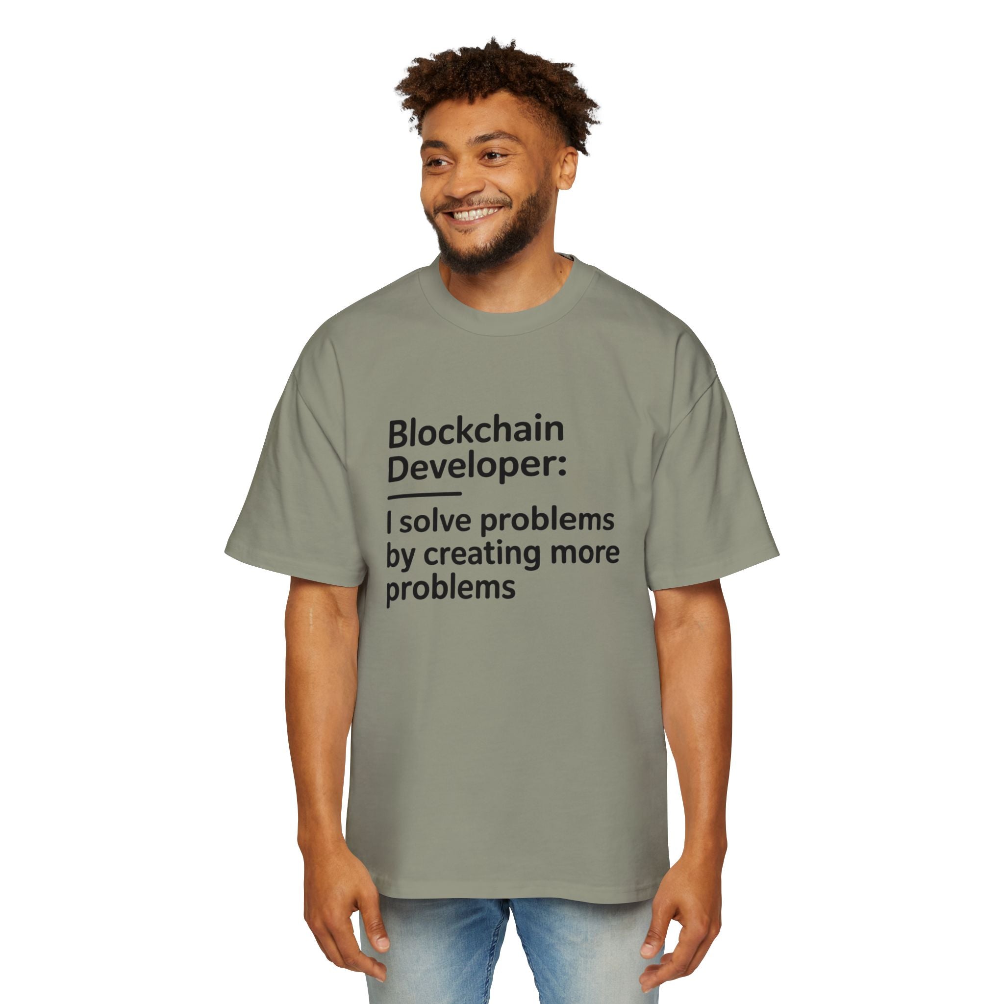 A man wears the Blockchain developer - Heavy Oversized Tee, made from 100% cotton in light gray, with "Blockchain Developer: I solve problems by creating more problems" printed in black.