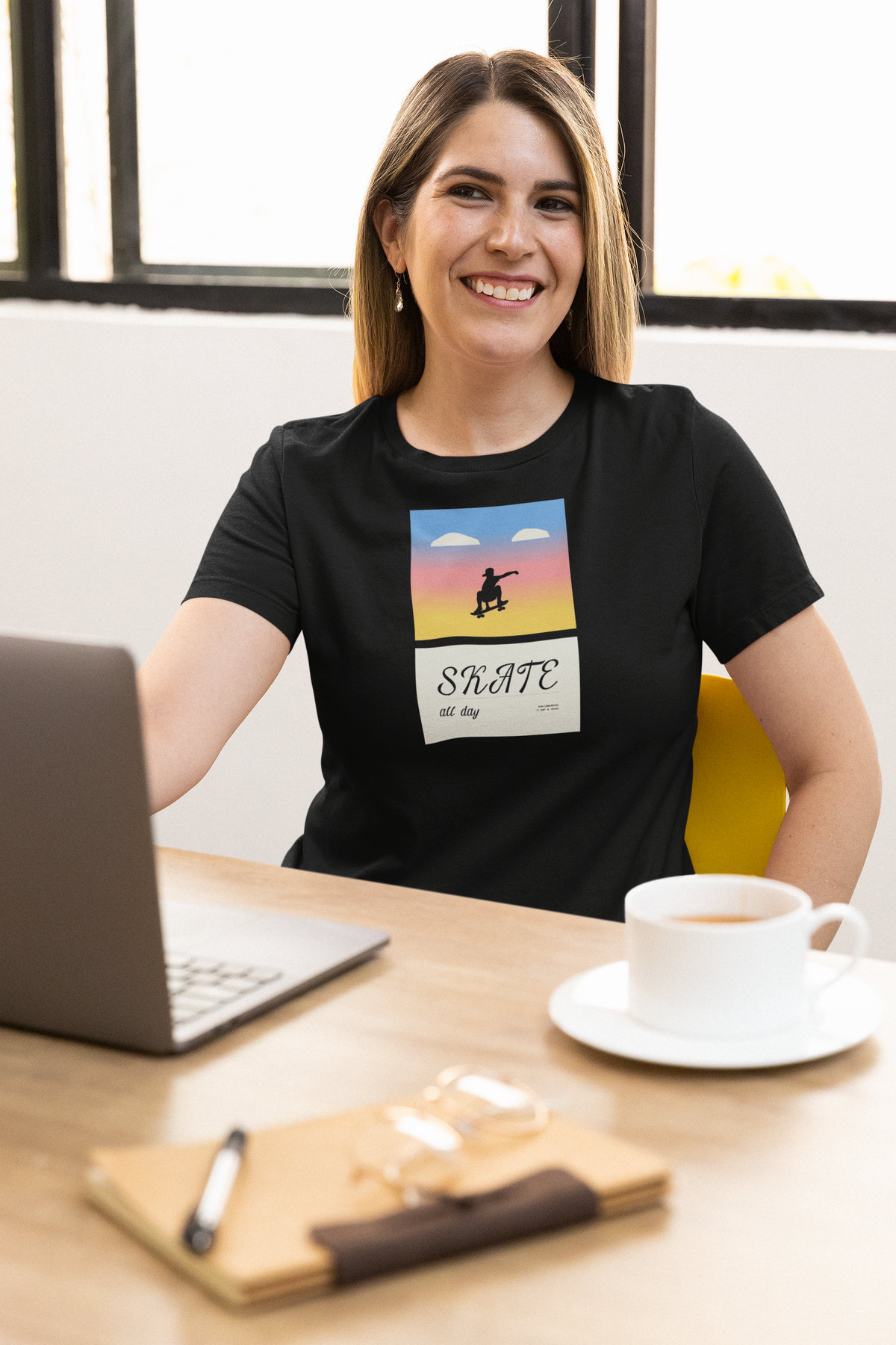 'Skate All Day' t-shirt in black, woman wearing it at an office desk, T-Shirt mockup, Geekpsters