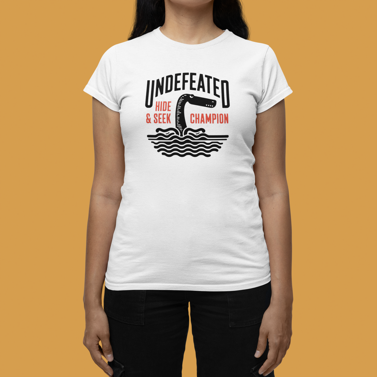 "Undefeated Hide and Seek Champion" women's tee in white, woman modeling it, funny game night gift
