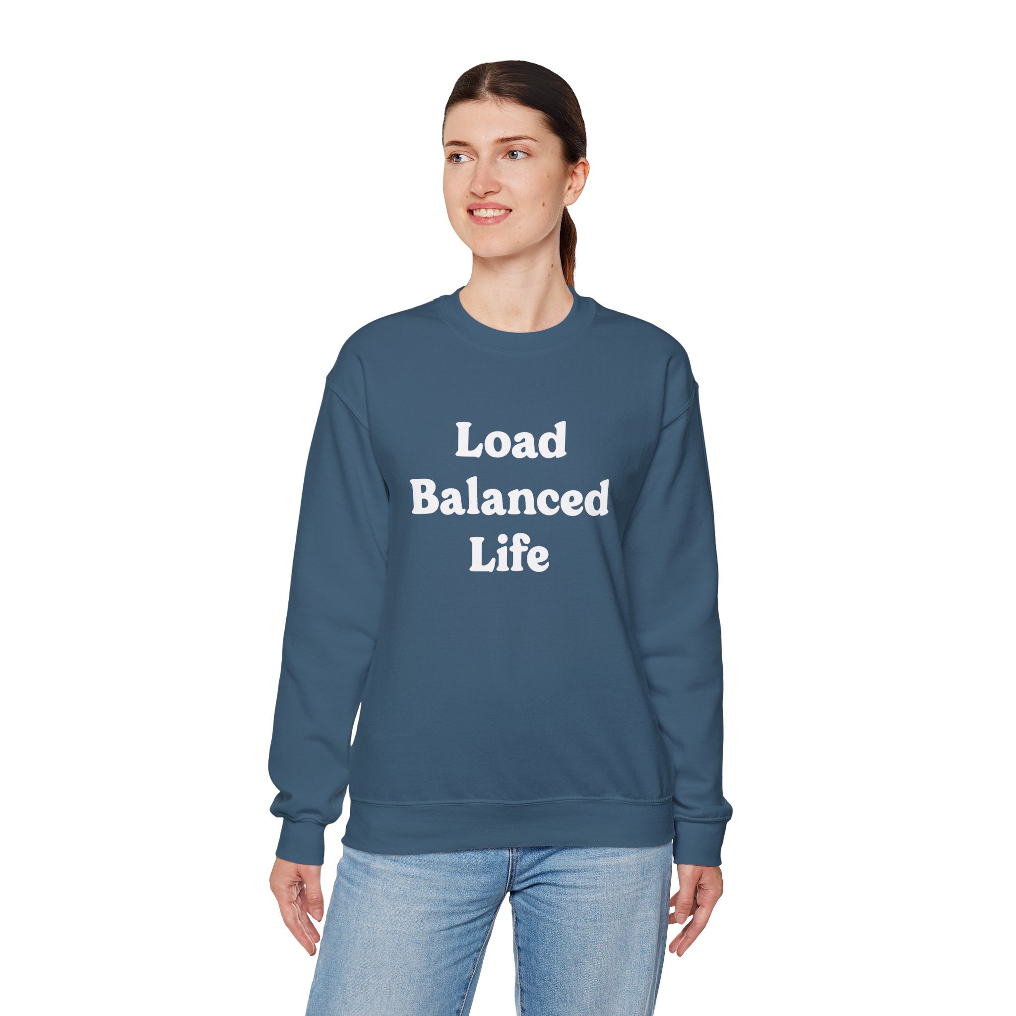 A person embodies cozy comfort in the Load Balanced Life sweatshirt, featuring a blue design, as they stand against a plain white background.