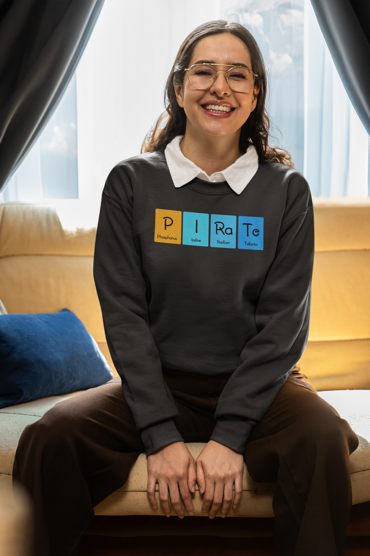 'P-I-Ra-Te' periodic table sweatshirt in charcoal, smiling woman wearing it at home, cozy lifestyle photo