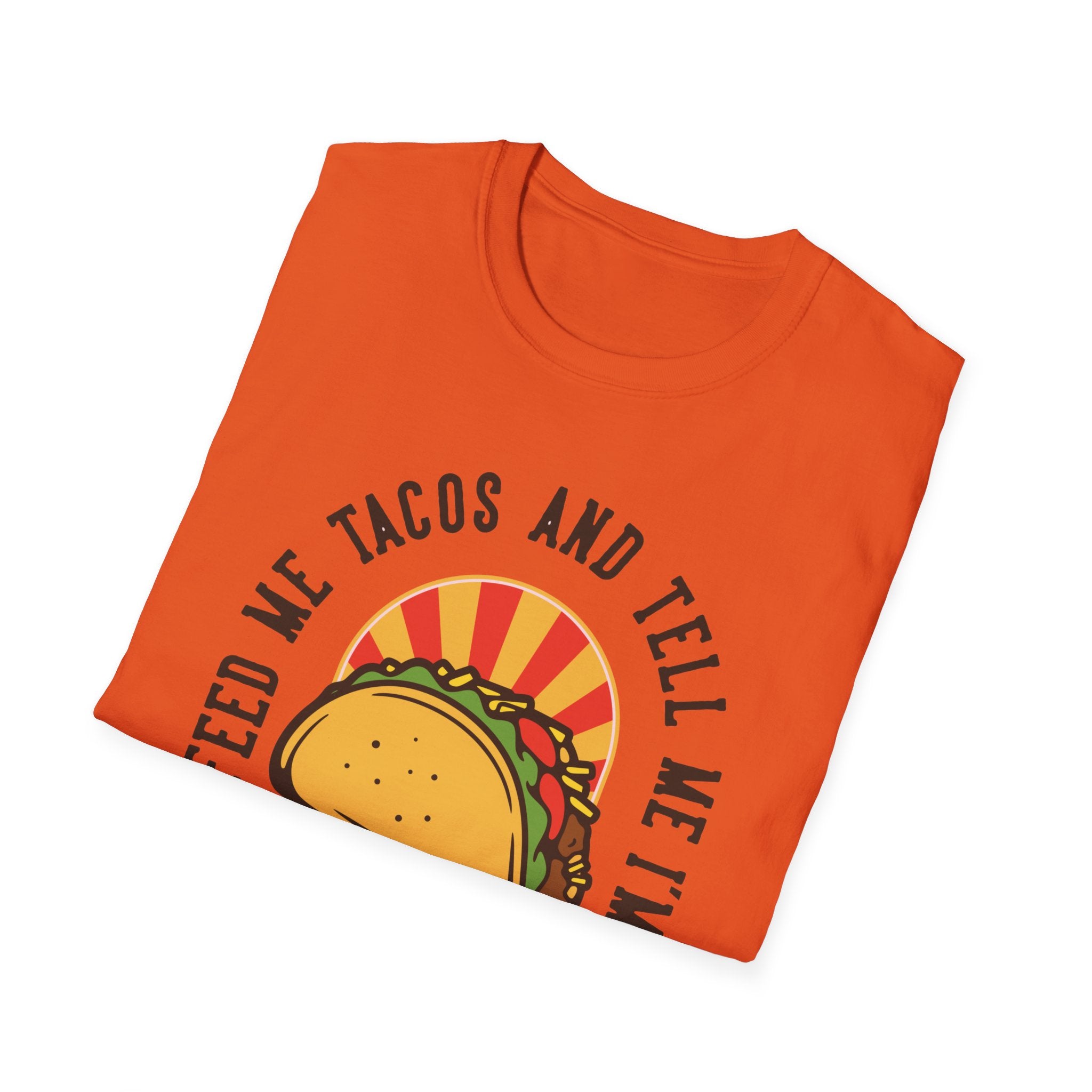 The "Feed Me Tacos and Tell Me I'm Pretty" T-Shirt, in orange, showcases a taco graphic with a circular design, making it ideal for taco enthusiasts to enjoy Taco Tuesdays in style.