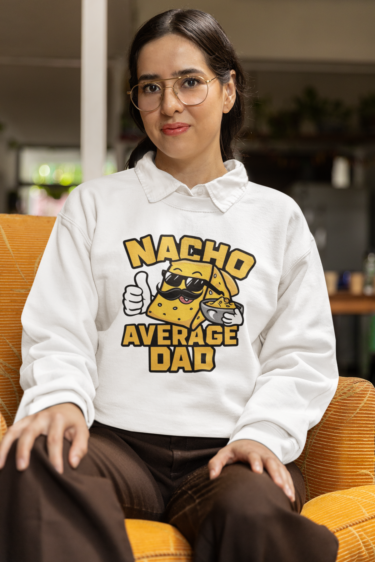 "Nacho Average Dad" sweatshirt in white, woman wearing it indoors, funny gift for nacho loving dads
