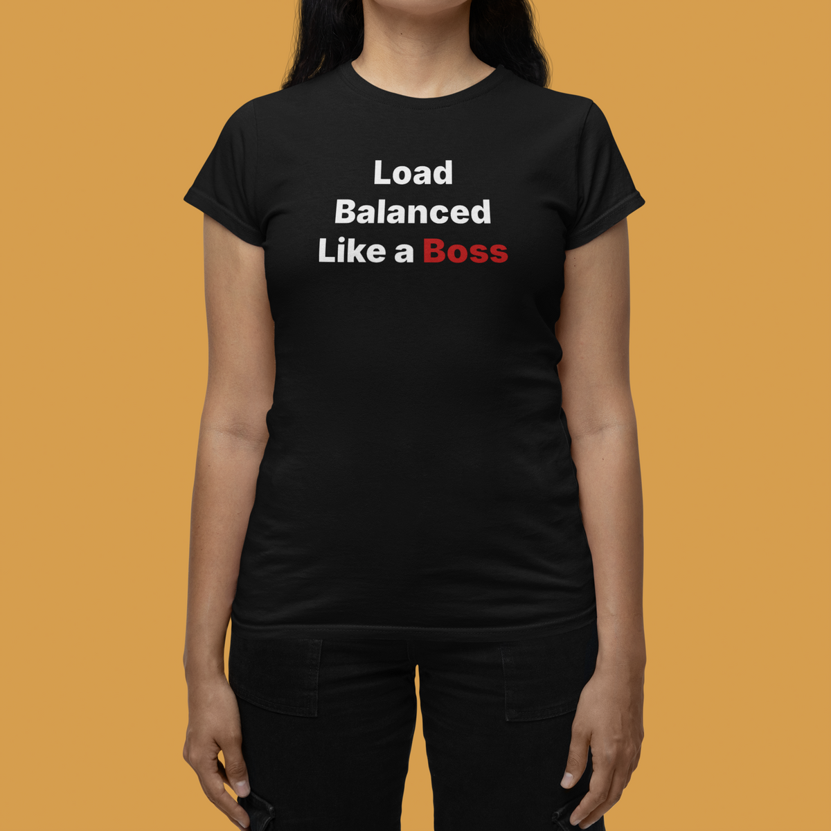 'Load Balanced Like a Boss' women's tee in black, woman wearing it on tan background, funny IT gift