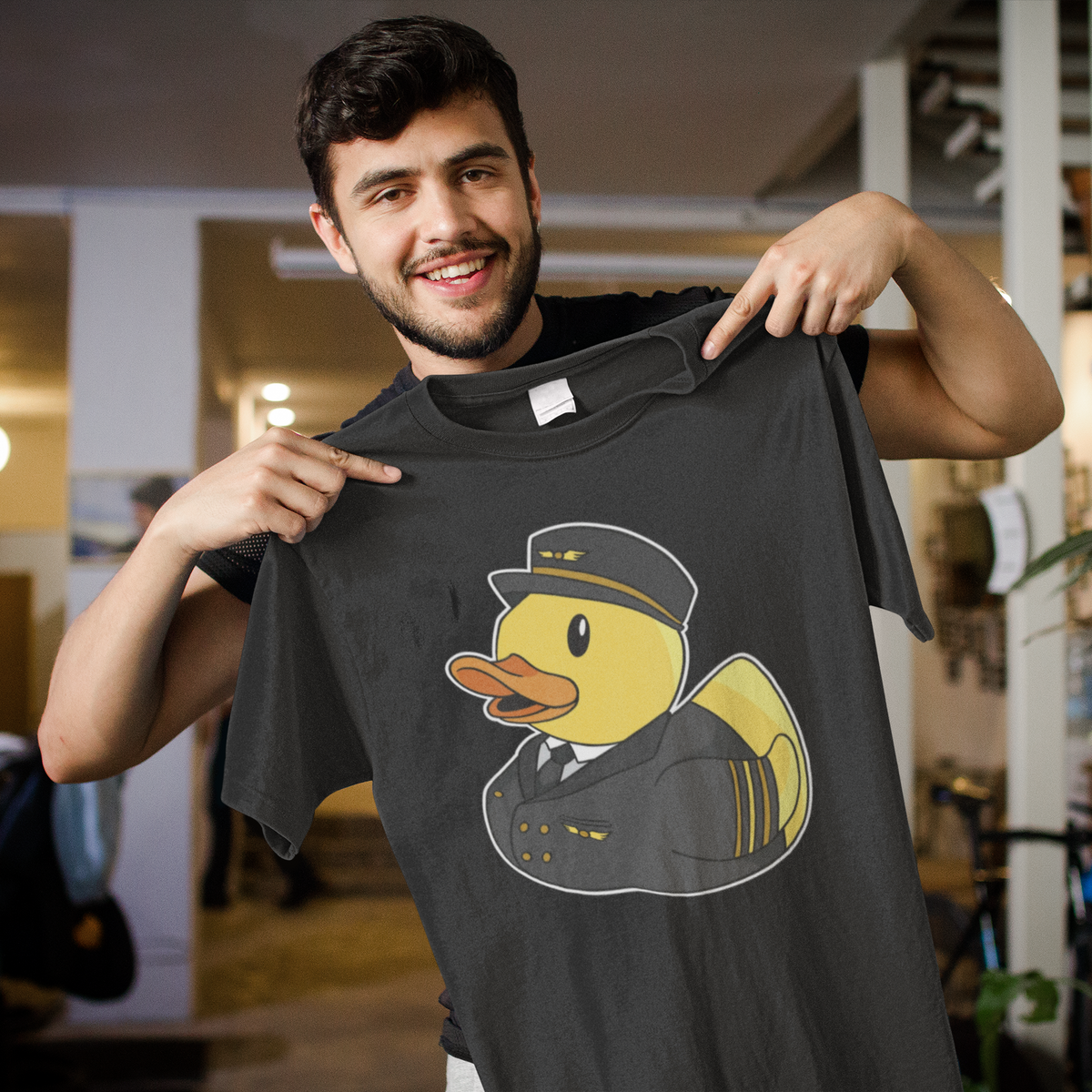 Pilot duck t-shirt in black, man model holding it up indoors, funny gift for aviation lovers