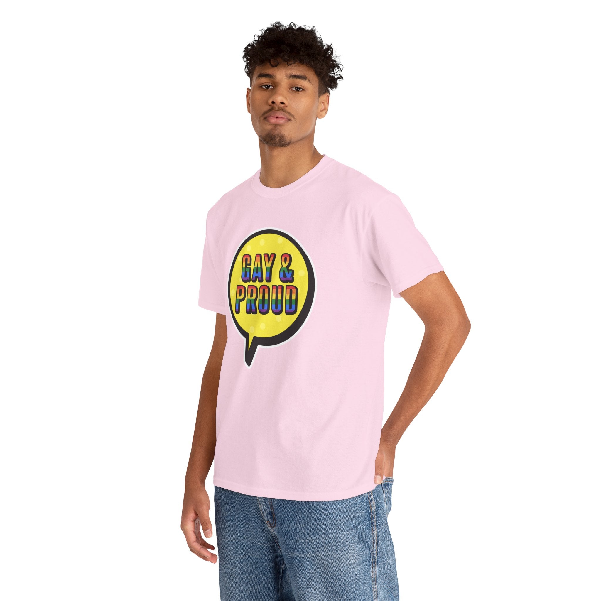 A person wearing the "Gay & Proud T-Shirt," which is a comfortable light pink cotton tee featuring a yellow speech bubble graphic, paired with blue jeans for everyday wear.