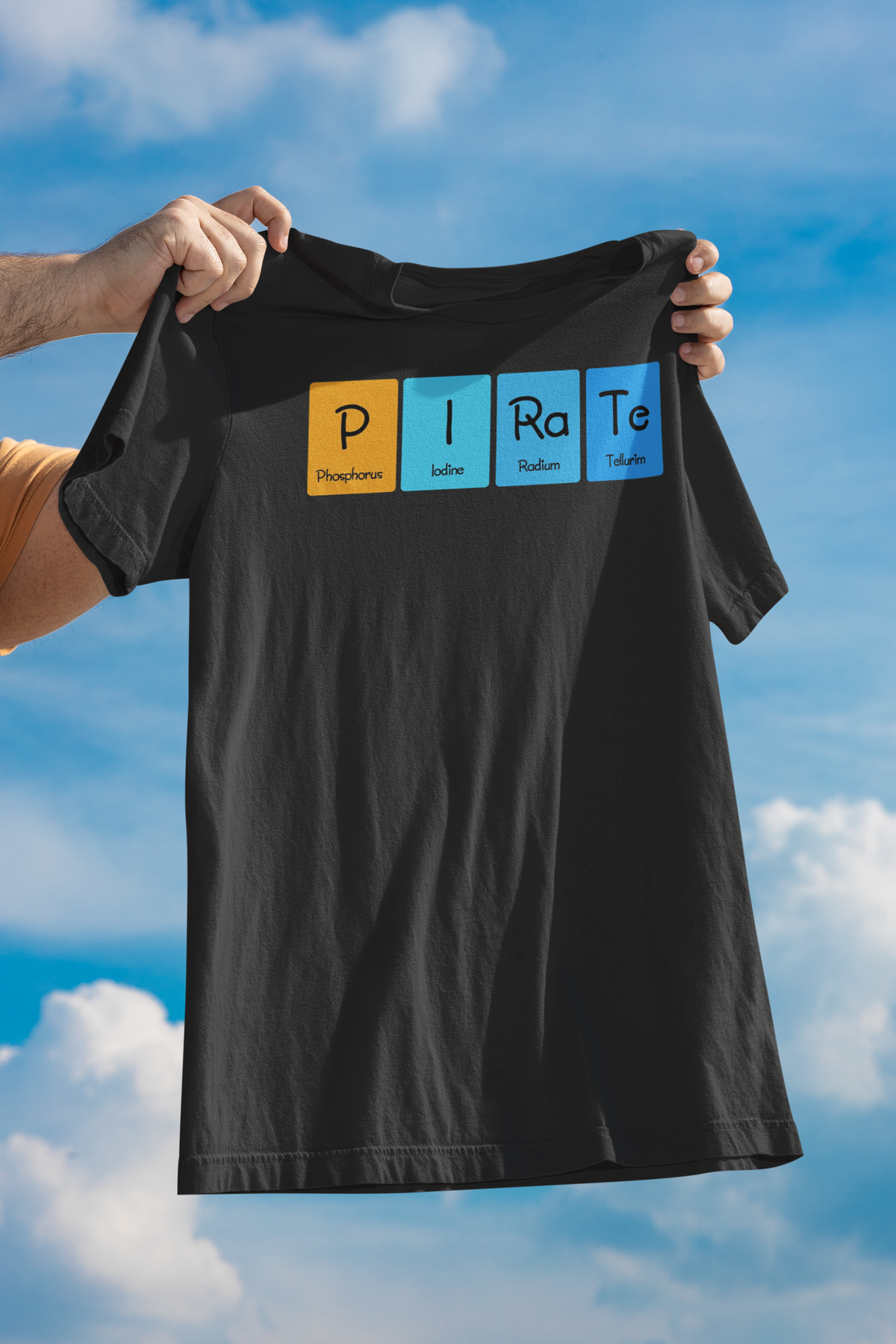 'P-I-Ra-Te' periodic table t-shirt in black, man holding it up against a blue sky, funny chemistry gift