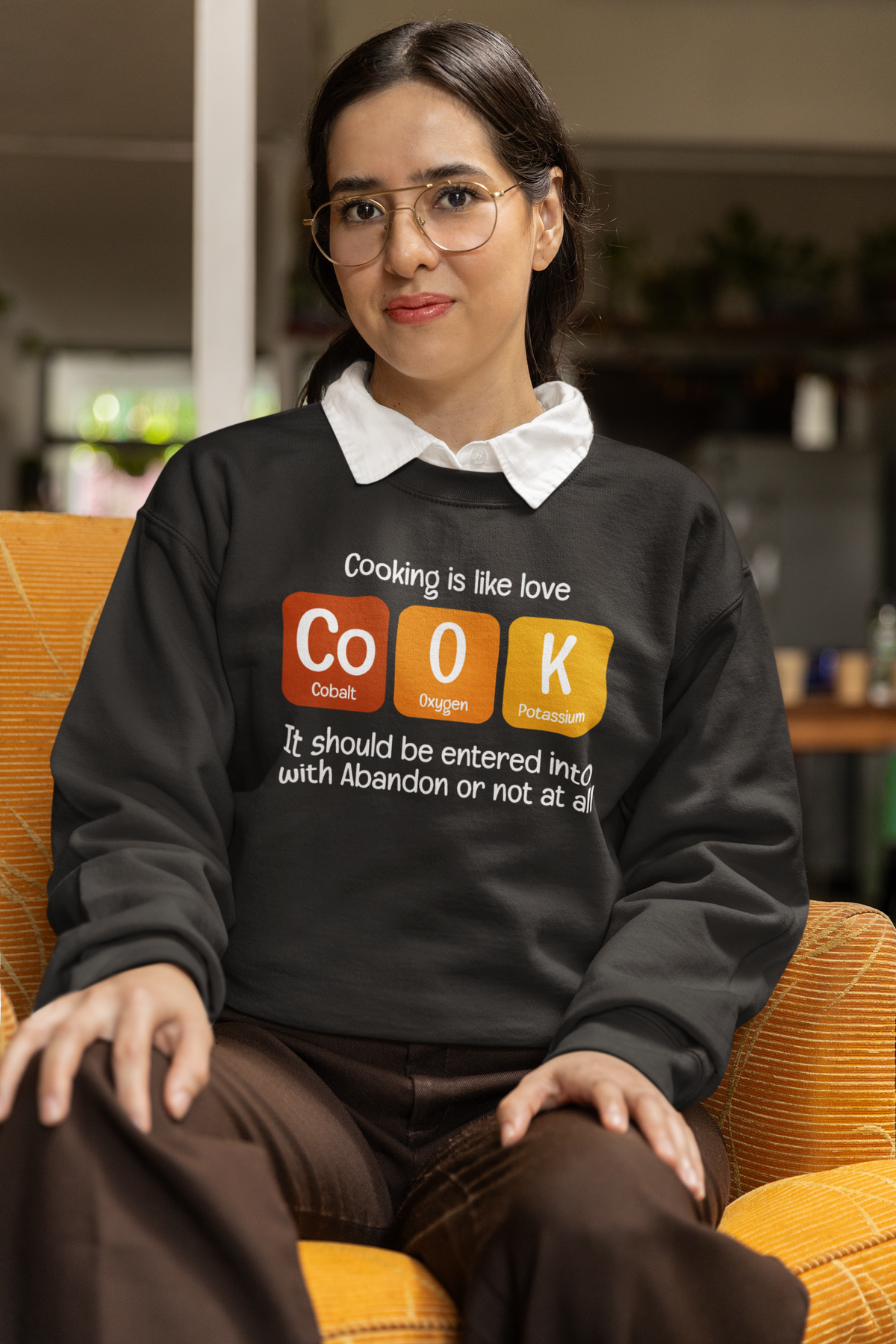 Co-O-K periodic table cook element pun crewneck sweatshirt, model wearing it indoors