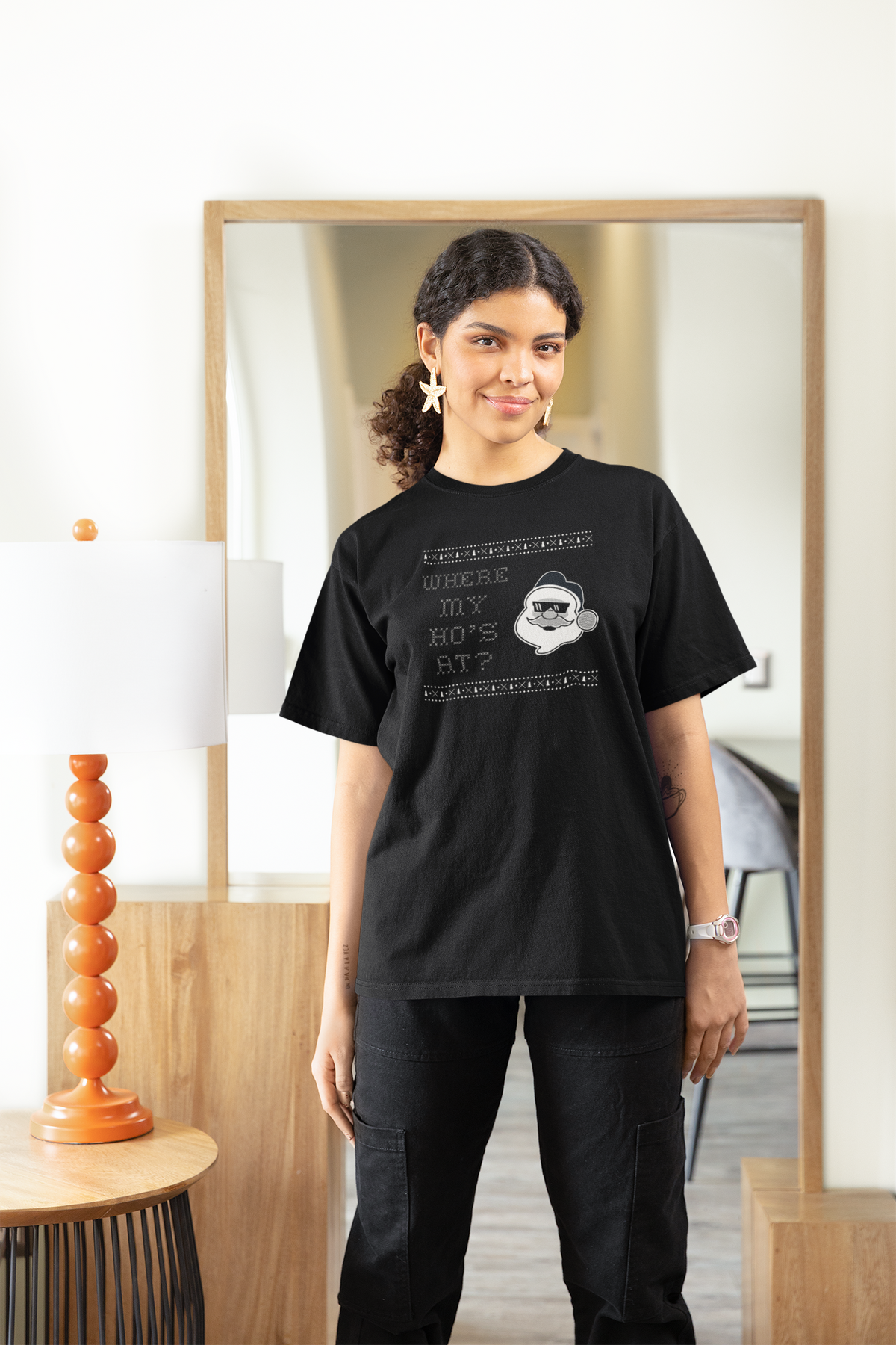 'Where My Ho's At' Santa graphic women's tee in black, woman wearing it at home, funny Christmas tee gift for her