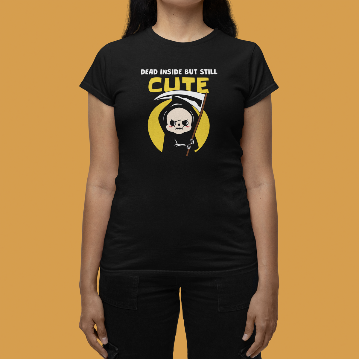'Dead Inside but Still Cute' women's tee in black, woman wearing it against a yellow backdrop, funny gothic gift