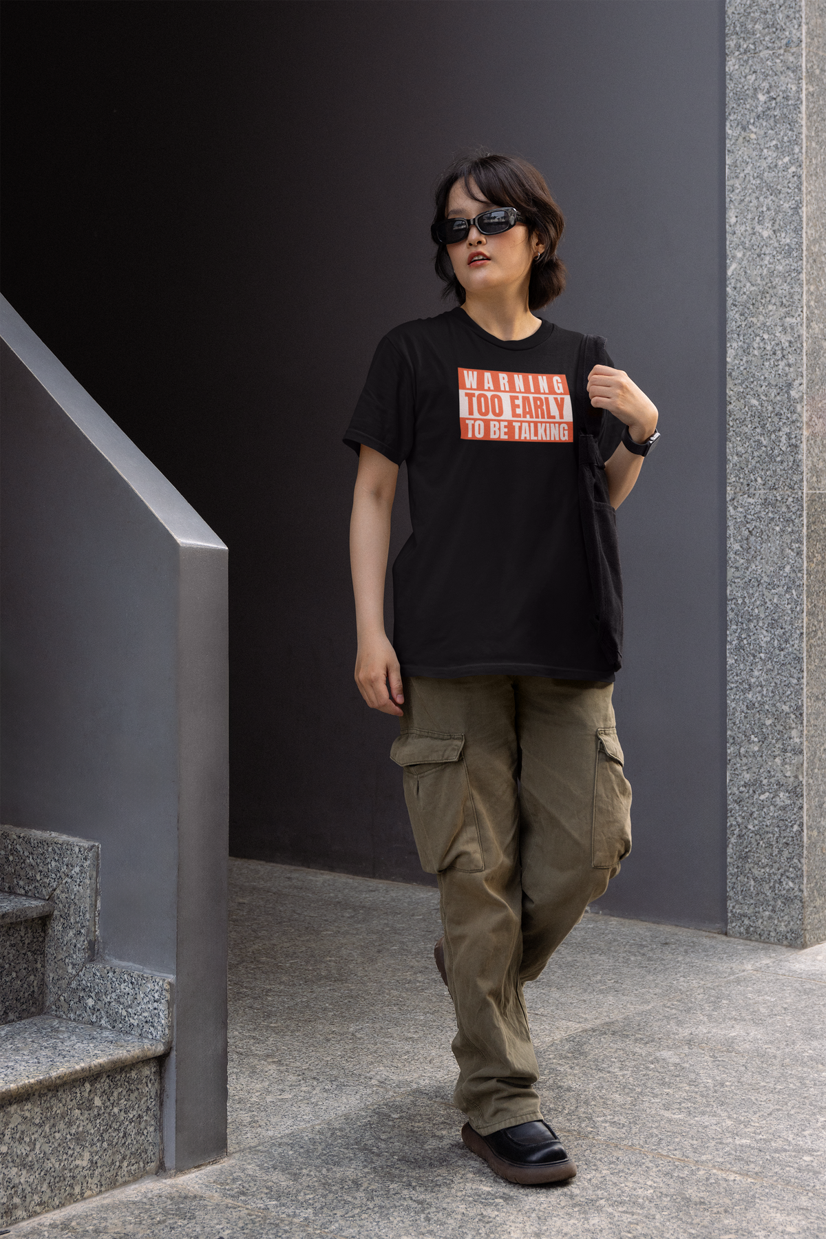 'Warning Too Early To Be Talking' t-shirt in black, man walking outdoors wearing it, funny gift idea