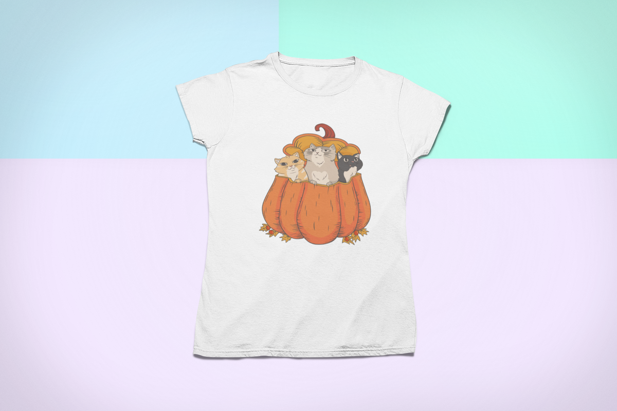Halloween Cats in a pumpkin T-shirt in white, flat lay on a pastel backdrop, funny cat halloween gift